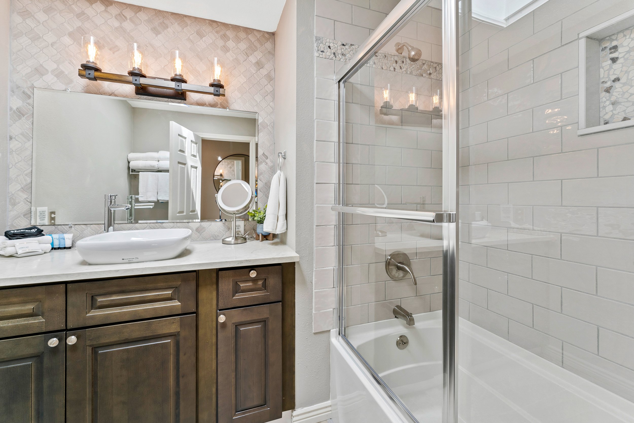 Spa-quality hall bath with subway tile, vessel sink, and quartz vanity