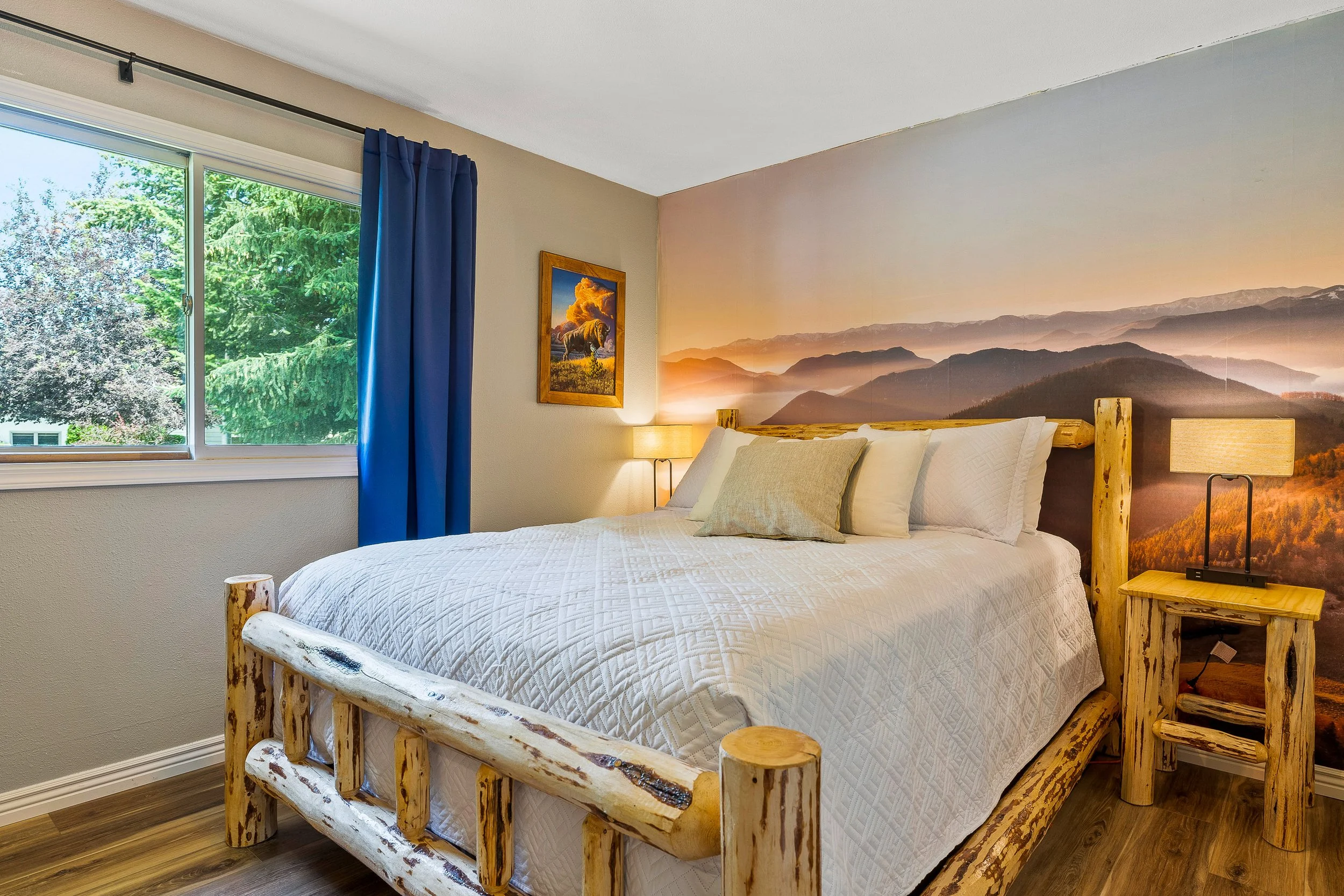 Second bedroom with queen log bed and Montana mountain sunrise mural
