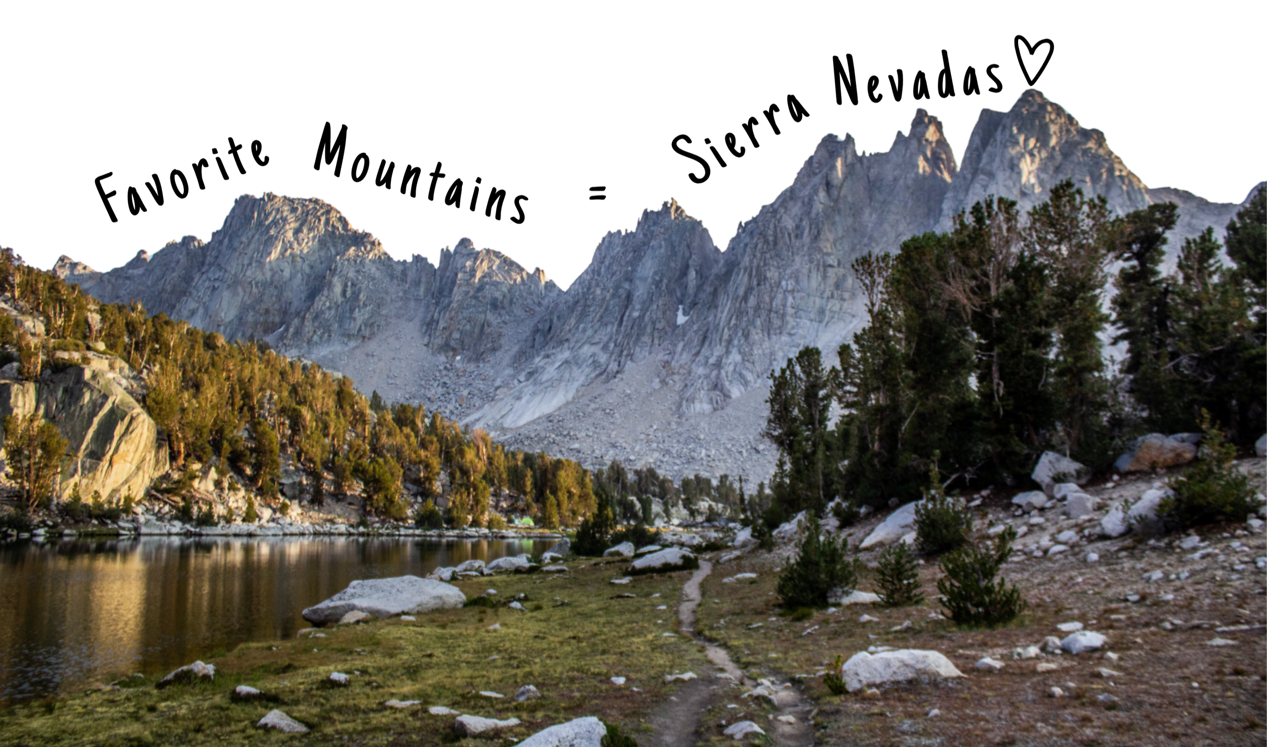 Mountain range with rocky peaks, trees in the foreground, and a calm lake reflecting the scenery.