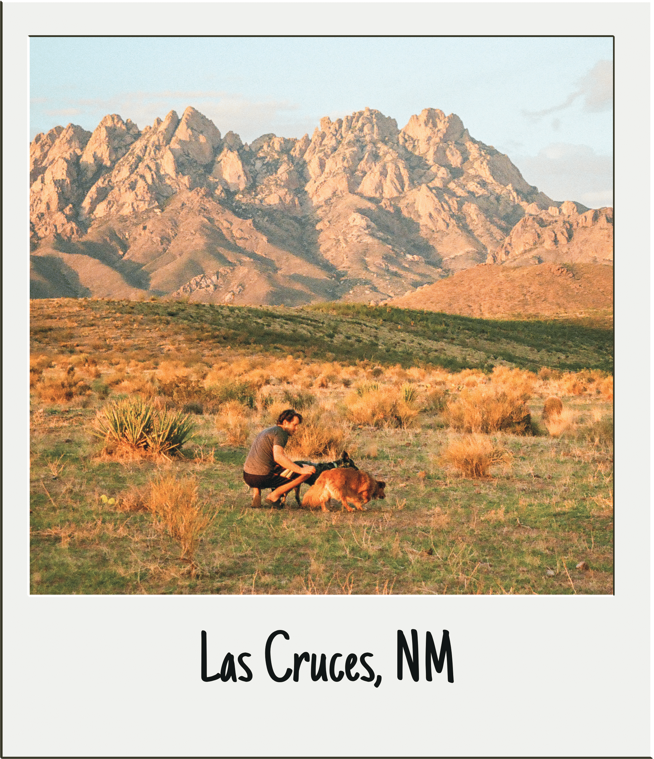 Landscape view of Organ Mountains at sunset in Las Cruces, New Mexico, with a person with a dog in the foreground.