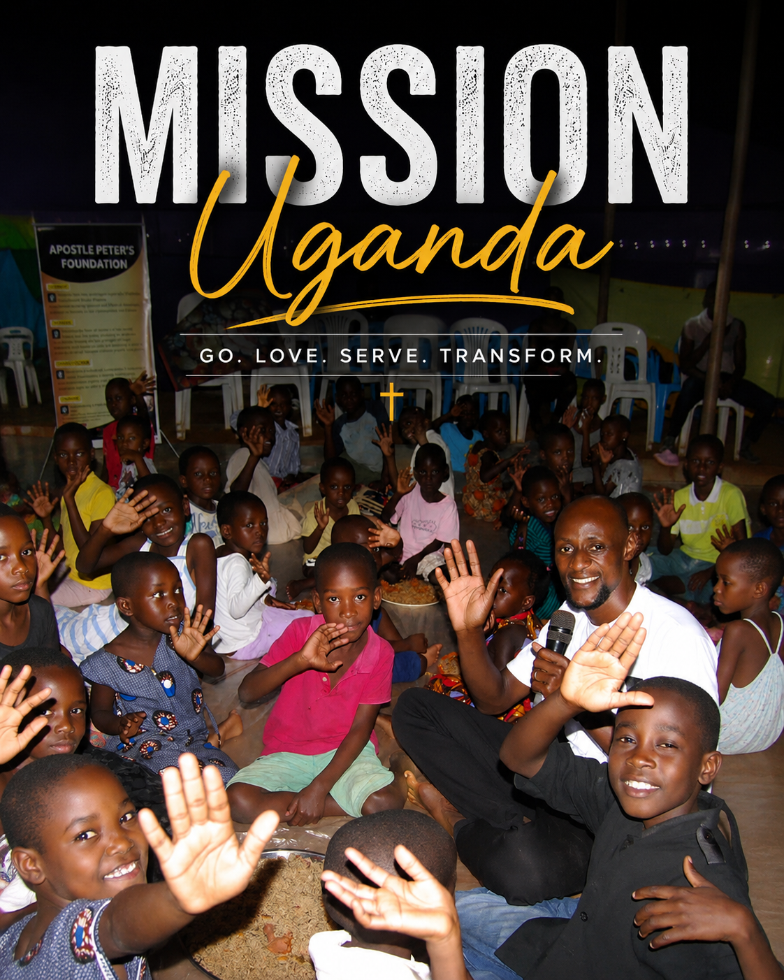 A group of children and adults in Uganda, smiling and waving at the camera, with a man holding a microphone at the front.