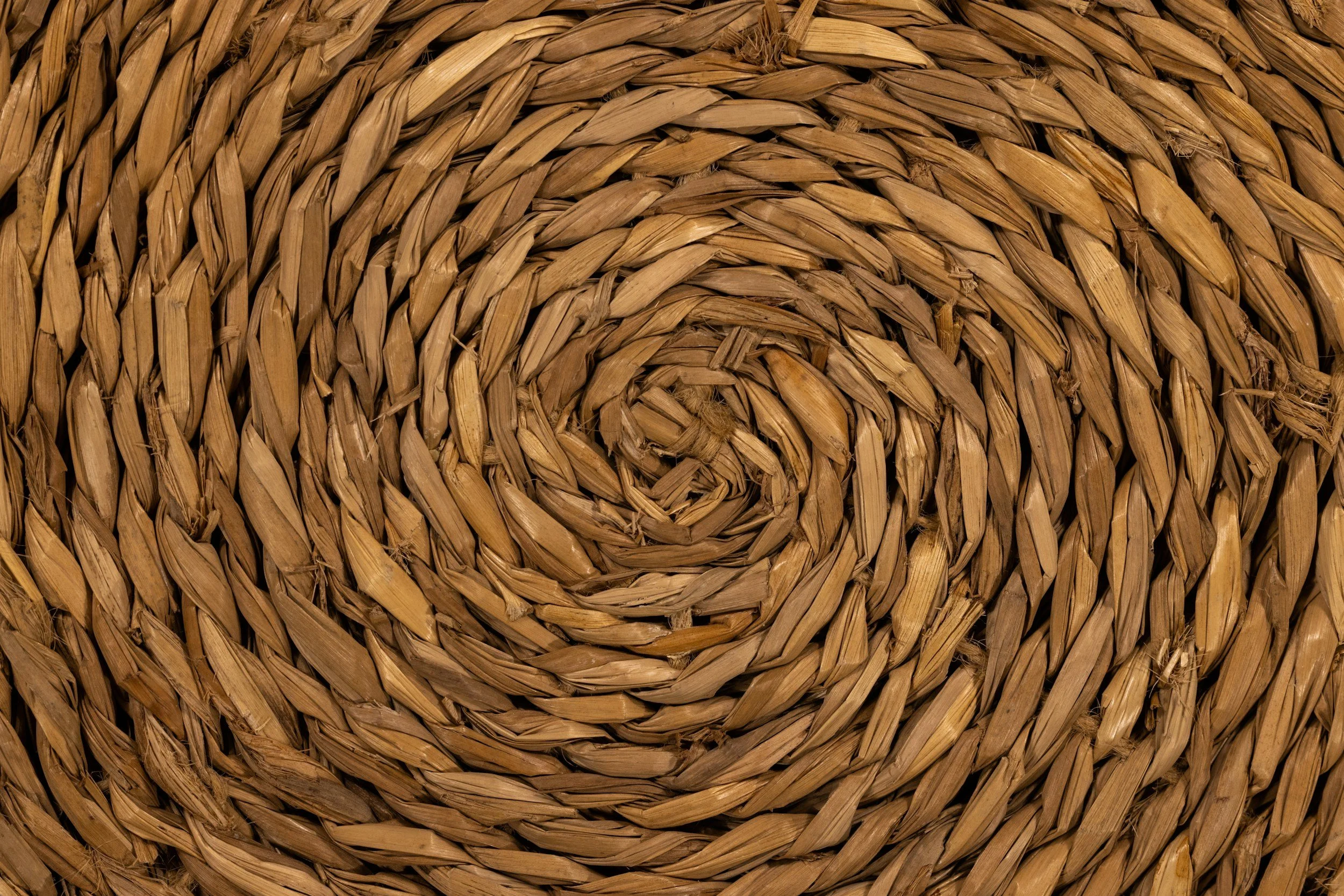 Close-up of a circular woven wicker basket, in natural brown tones.