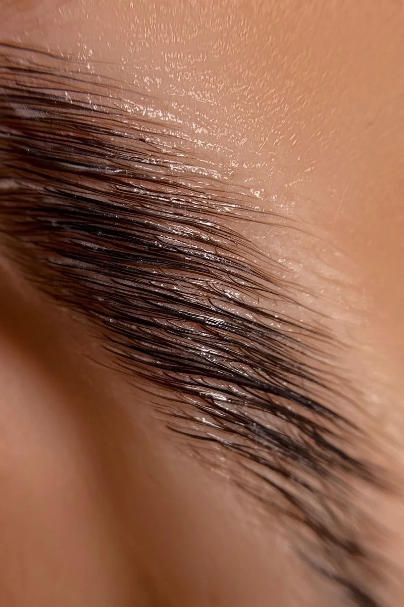 Close-up of a person's closed eye with wet eyelashes.