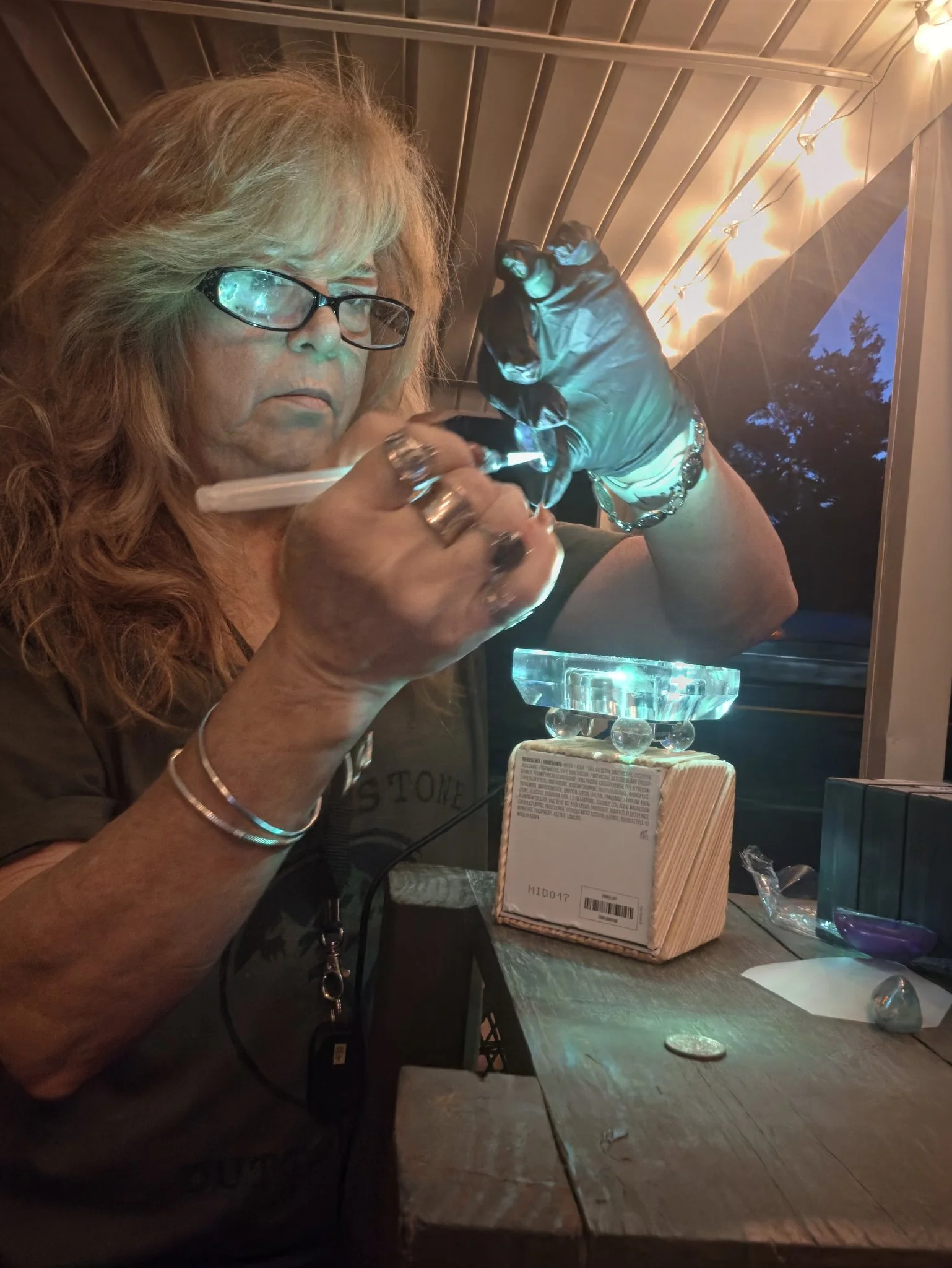 Sandra holding a glass portal up to the light in her studio
