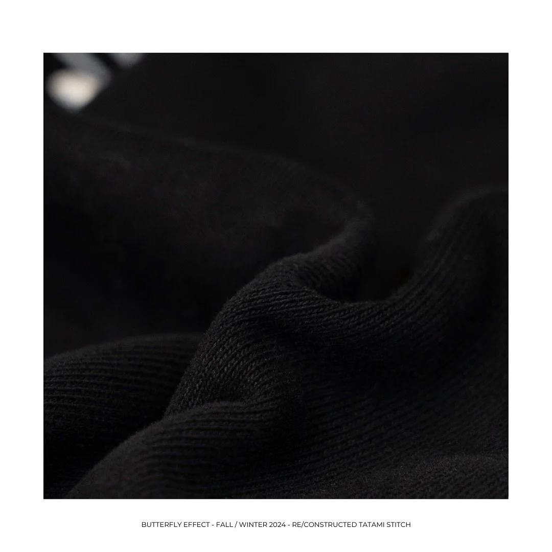 Close-up of black fabric with visible stitching and textured surface.
