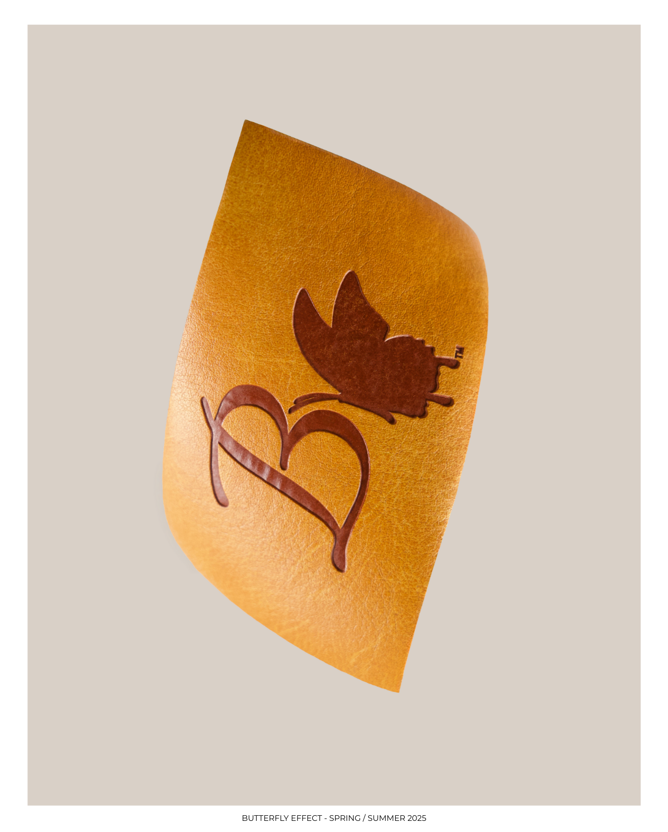 A textured orange-colored notebook or folder with a butterfly silhouette and a heart design cutout on the cover.