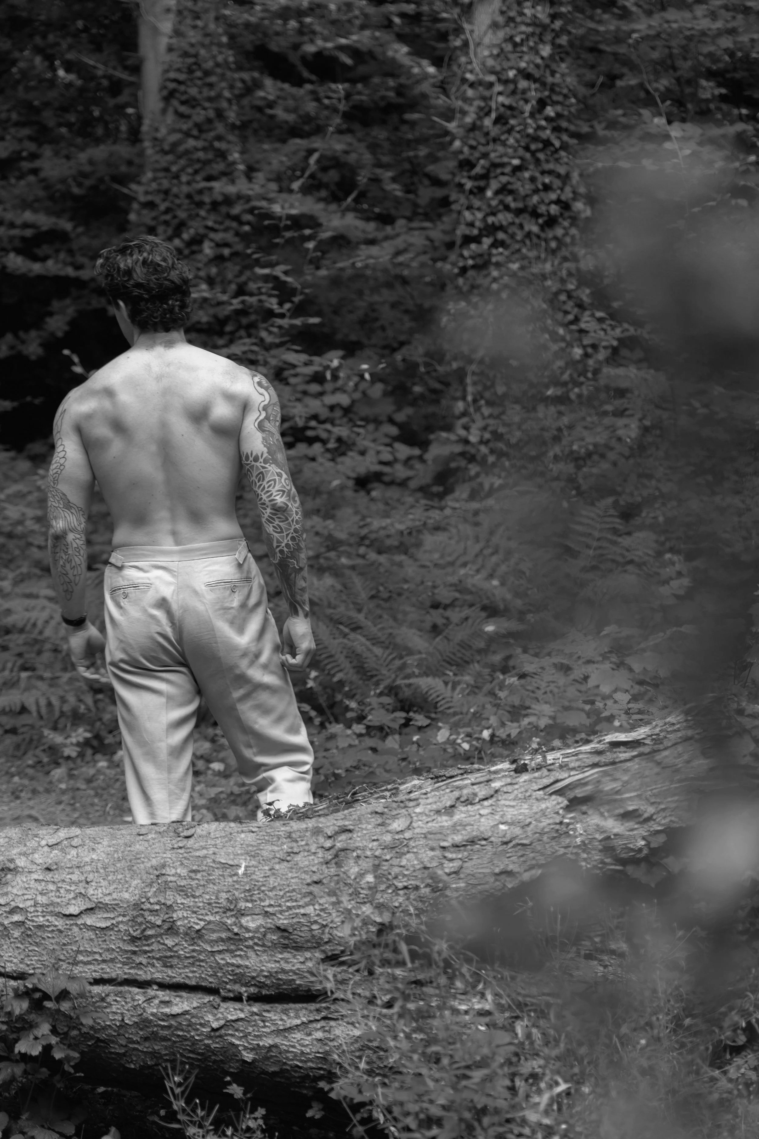 topless man in woods with tattoo sleeve