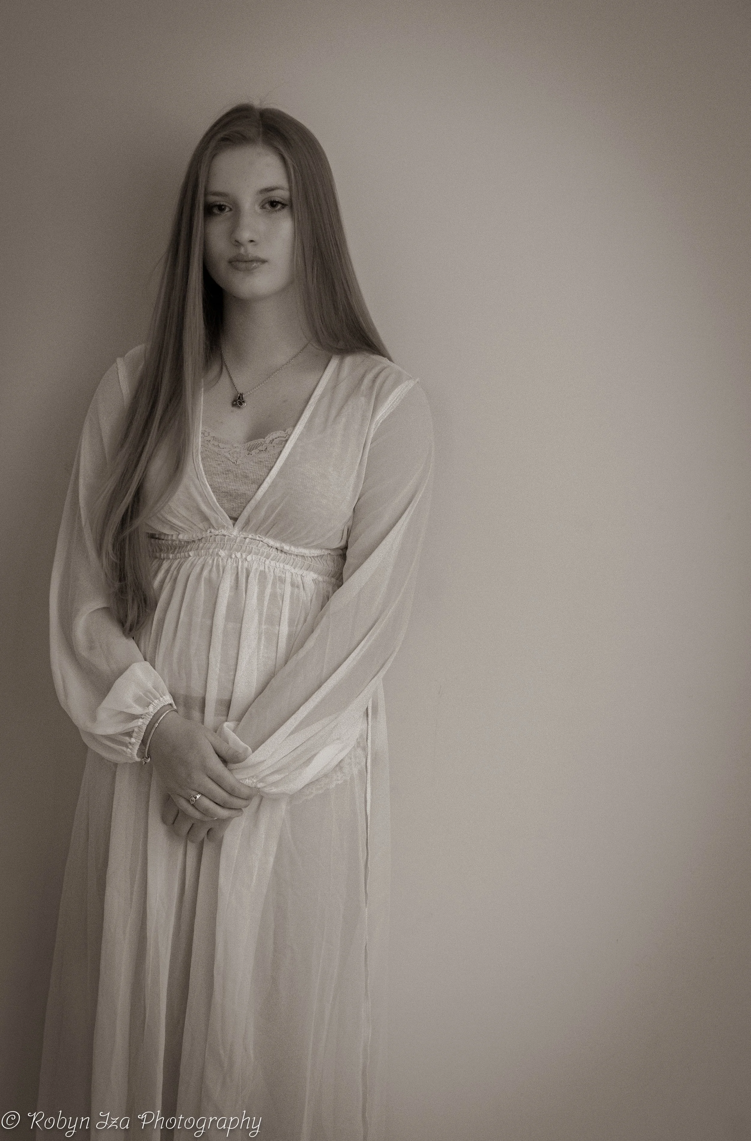 Blonde girl wearing white dress looking at camera