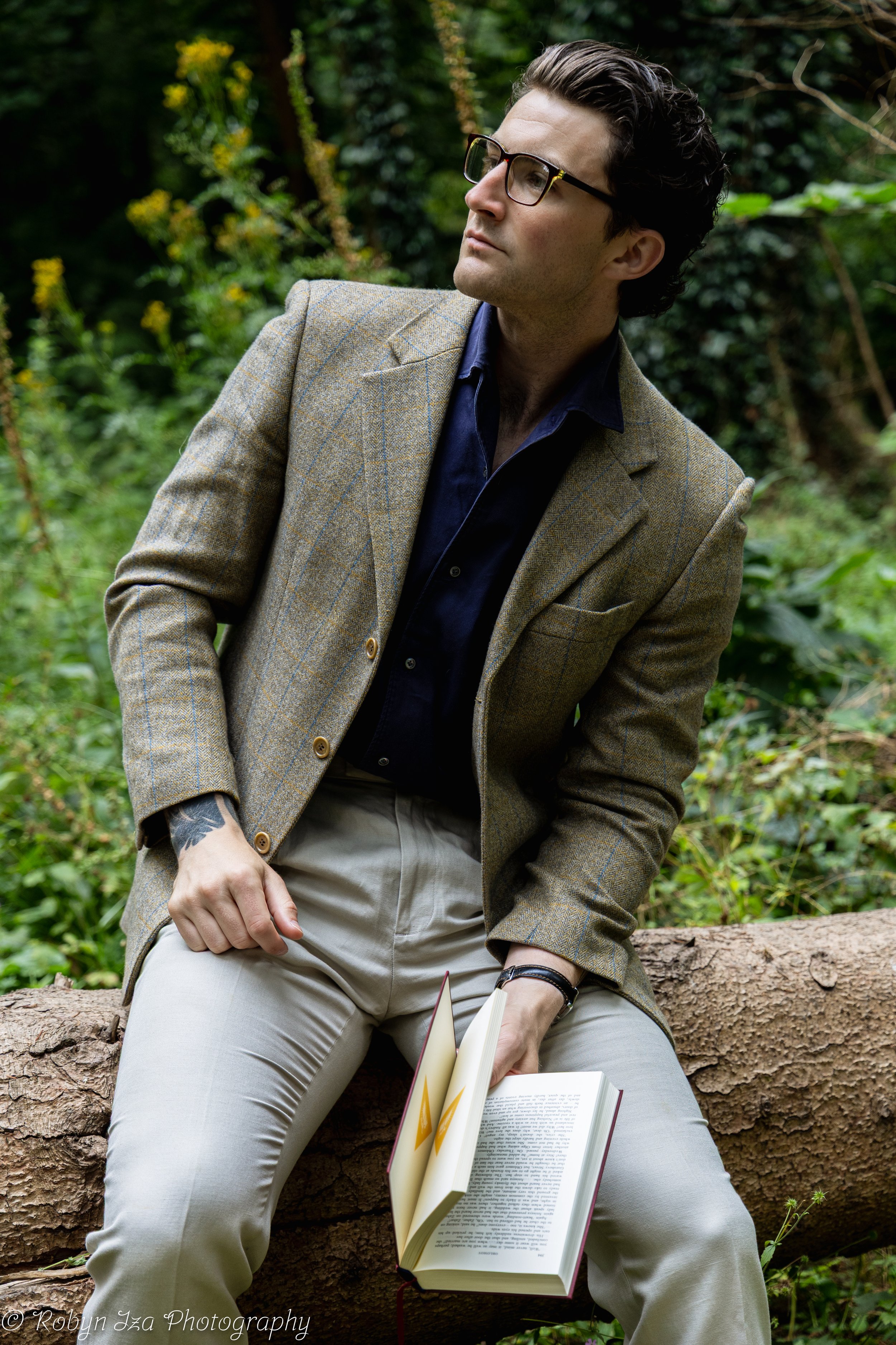 Man in woods wearing glasses and reading