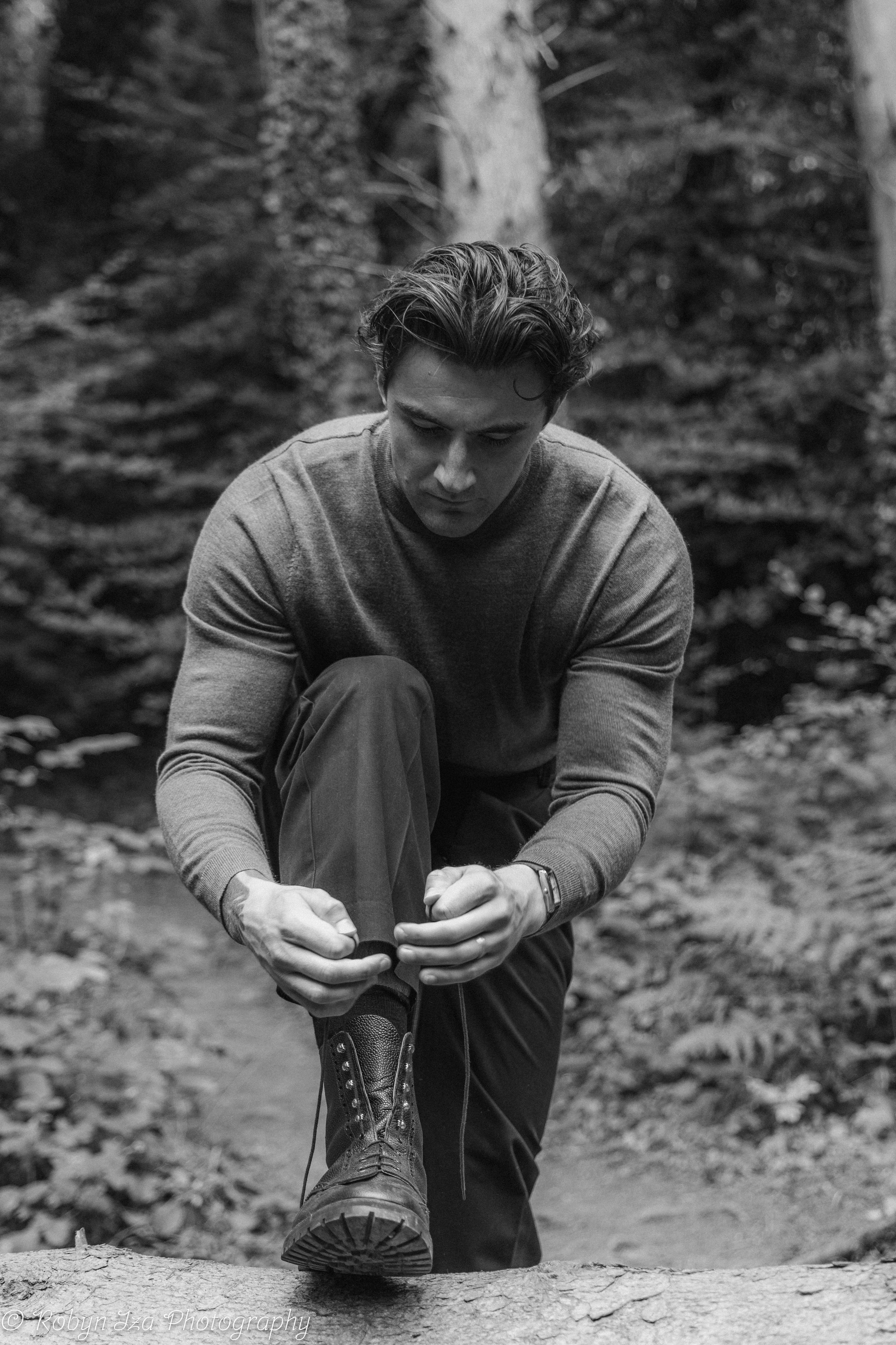 Man in woods tying boot laces
