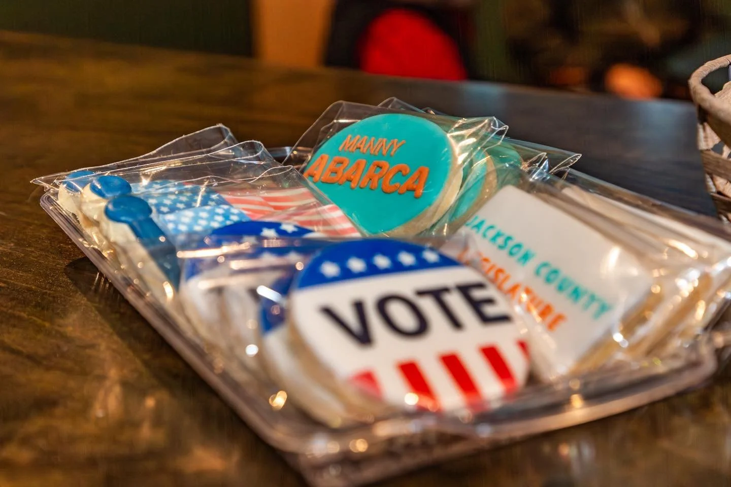 Collection of patriotic themed campaign cookies in clear plastic bags on a wooden table.