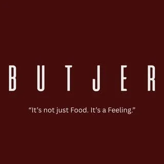 Text auf dunklem Rot-Hintergrund: 'BUTJER' mit dem Untertitel 'It's not just Food. It's a Feeling.'