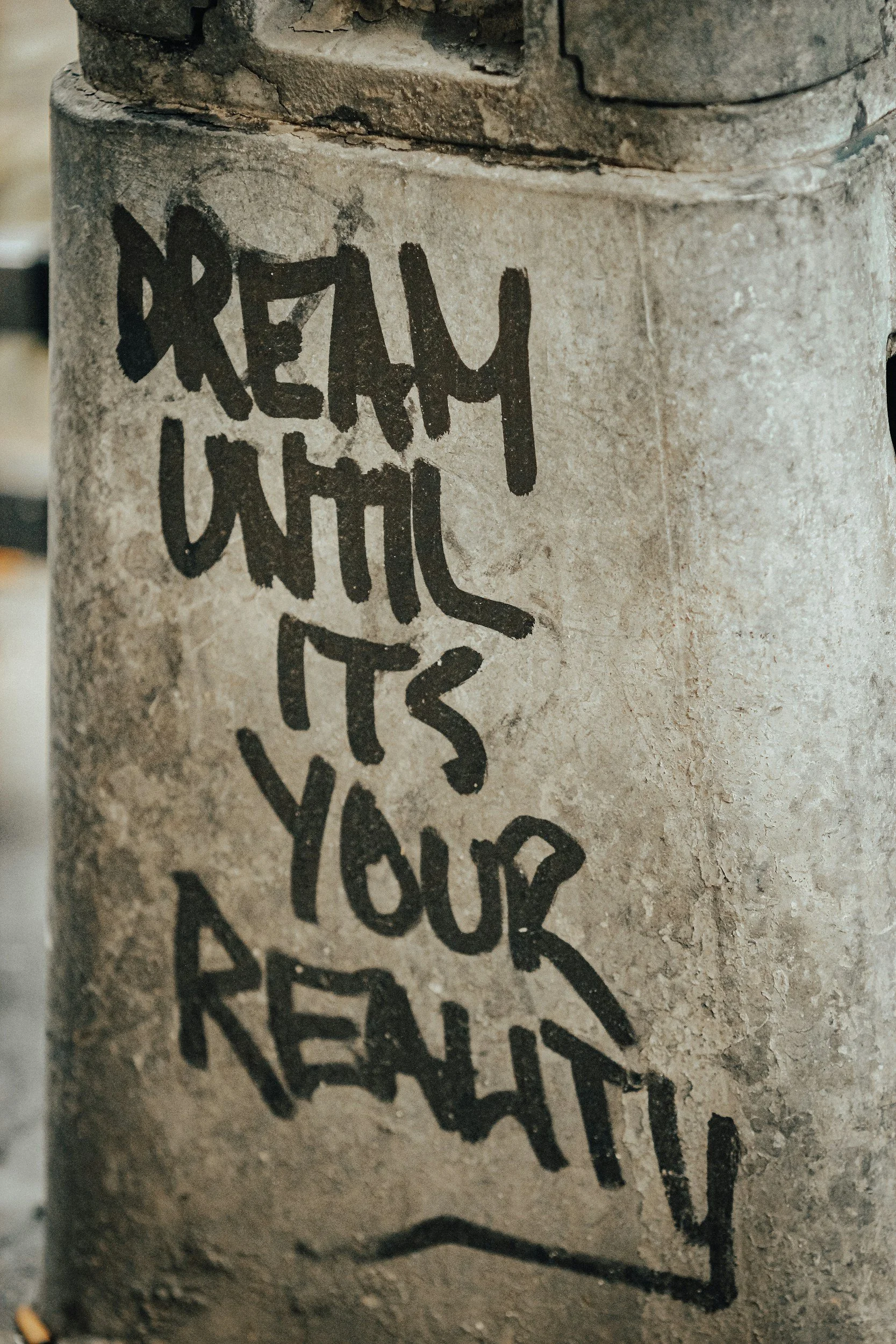 Close-up of graffiti on a concrete wall with the words "FREMY UNIC" and part of a design or letter below.