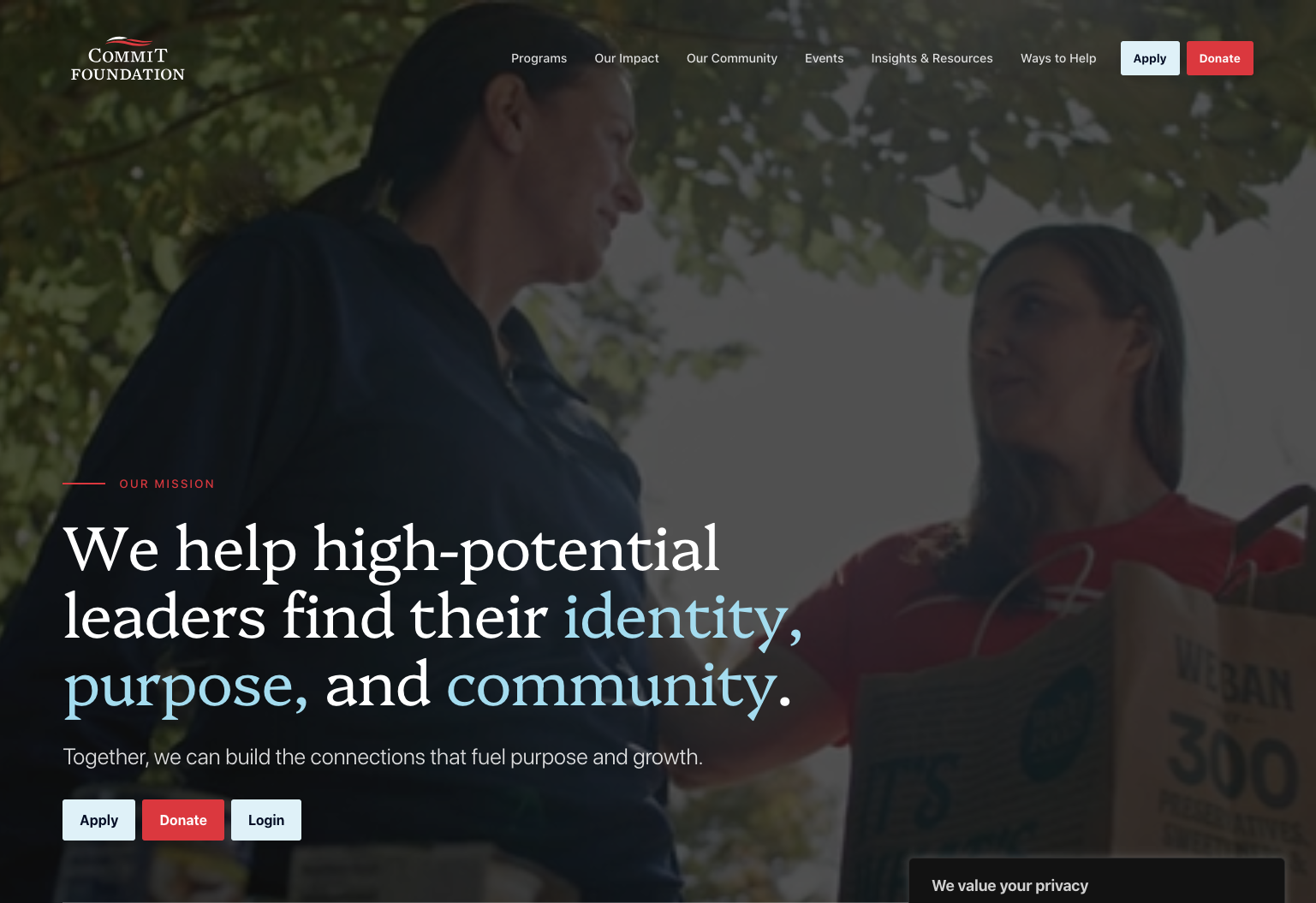 Website homepage for COMMIT Foundation featuring two people engaged in conversation under a tree, with navigation menu options for Programs, Our Impact, Our Community, Events, Insights & Resources, Ways to Help, and buttons for Apply, Donate, and Login.