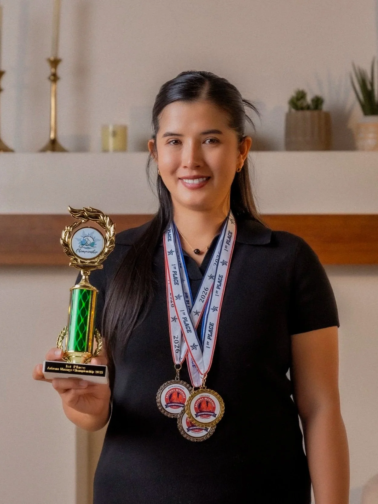 Pitchapa (Jane) Peeples holding trophy and medals from Arizona Massage Championship awards.