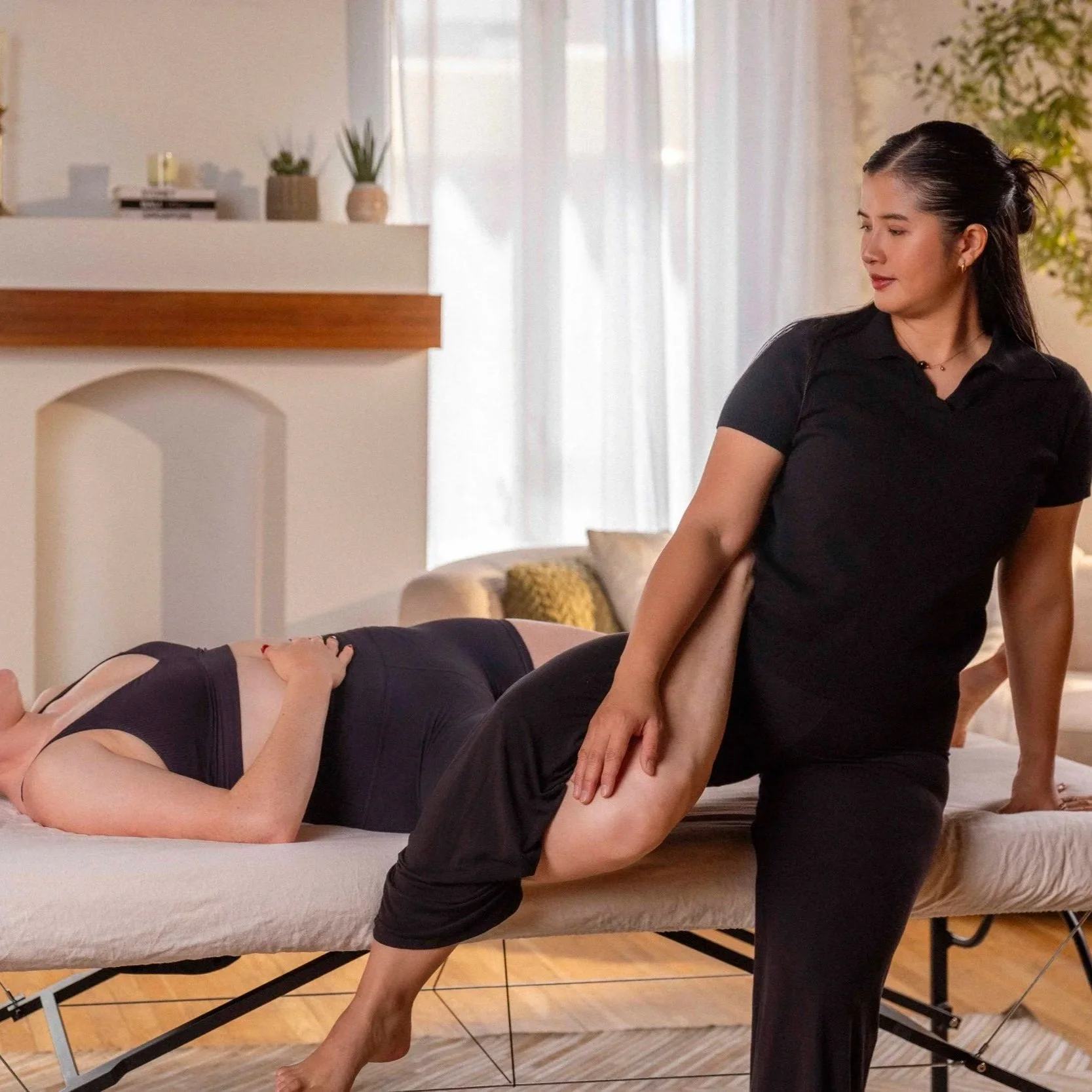 Mobile massage therapist performing table massage on a client's hip and lower back during an in-home session in Arizona