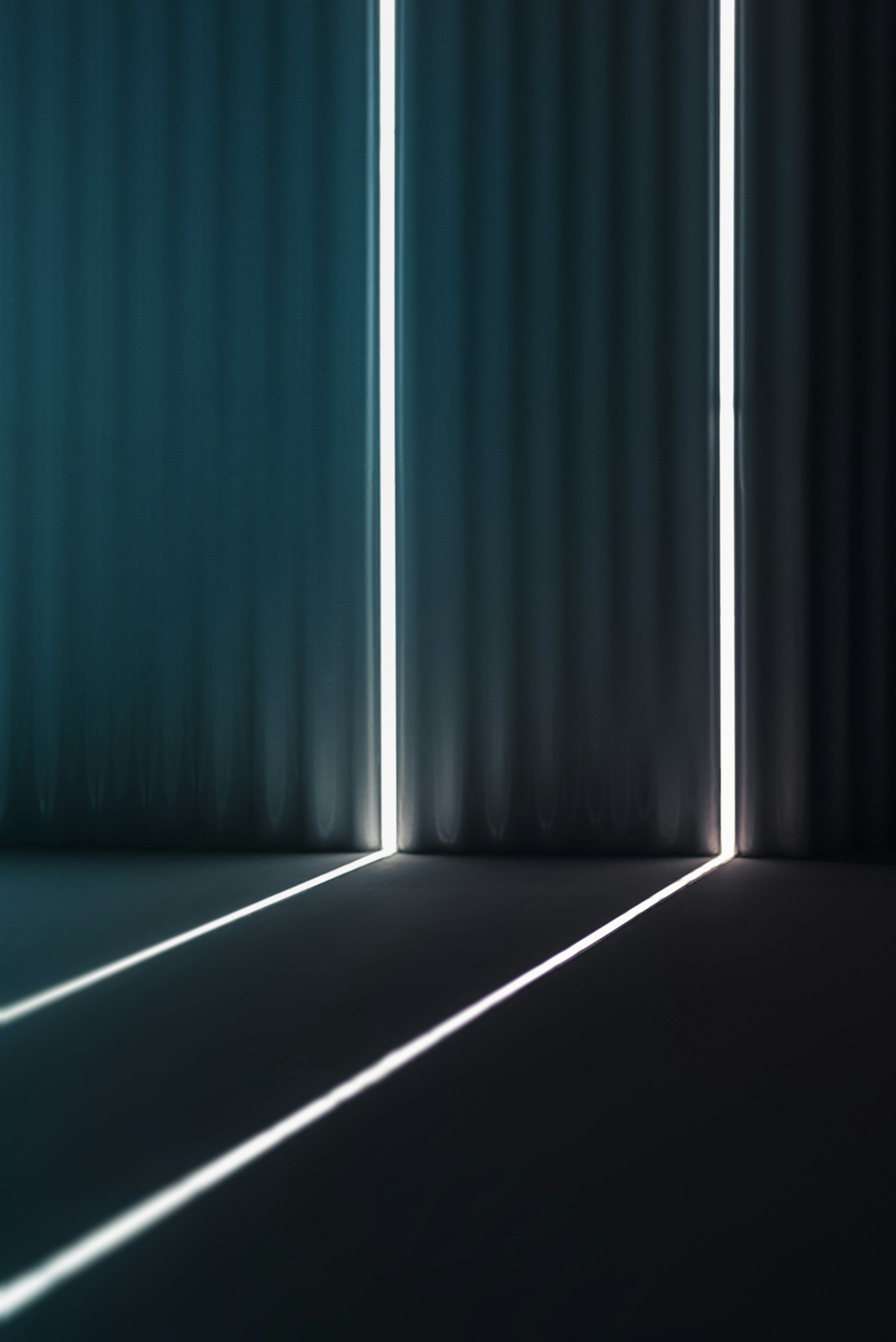 Puertas de elevador con luces blancas que forman líneas en la oscuridad.