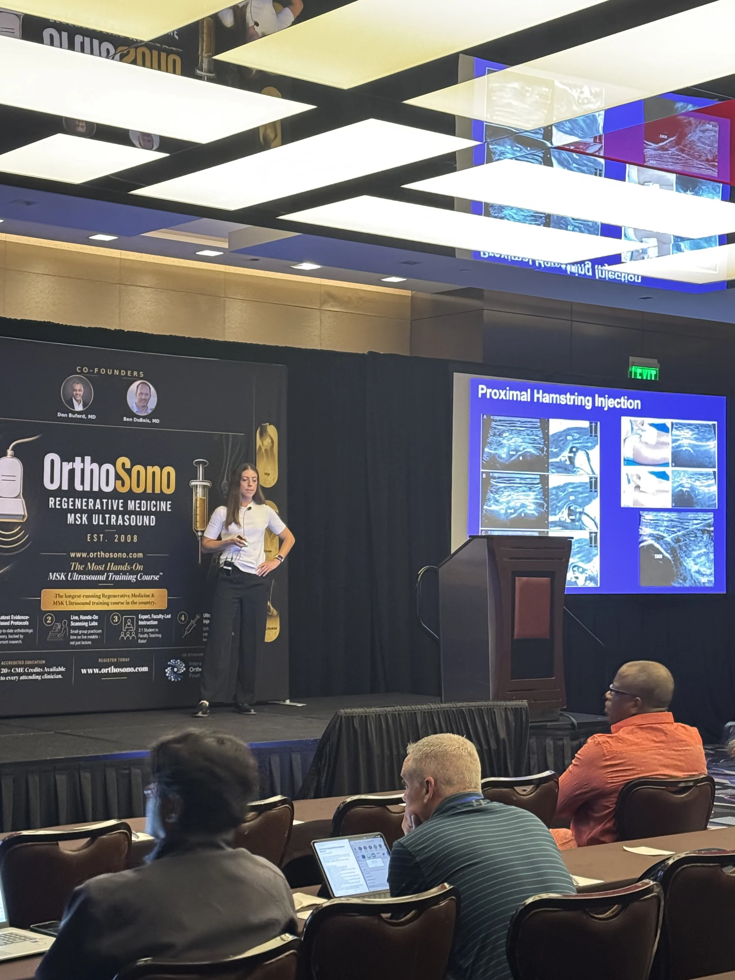 Dr. Melanie Worley presenting proximal hamstring injection techniques at the OrthoSono medical conference.