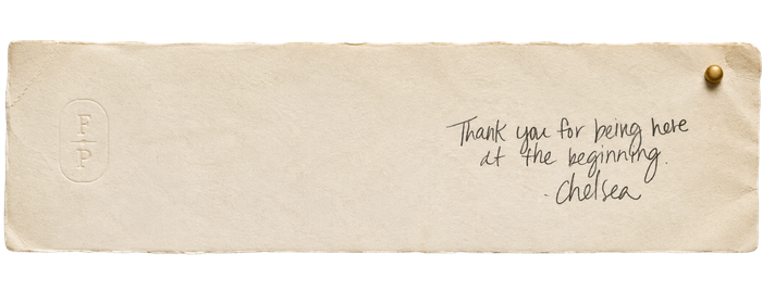 A cream-colored bookmark with the handwritten message, 'Thank you for being here at the beginning. - Chelsea,' attached with a gold pin.