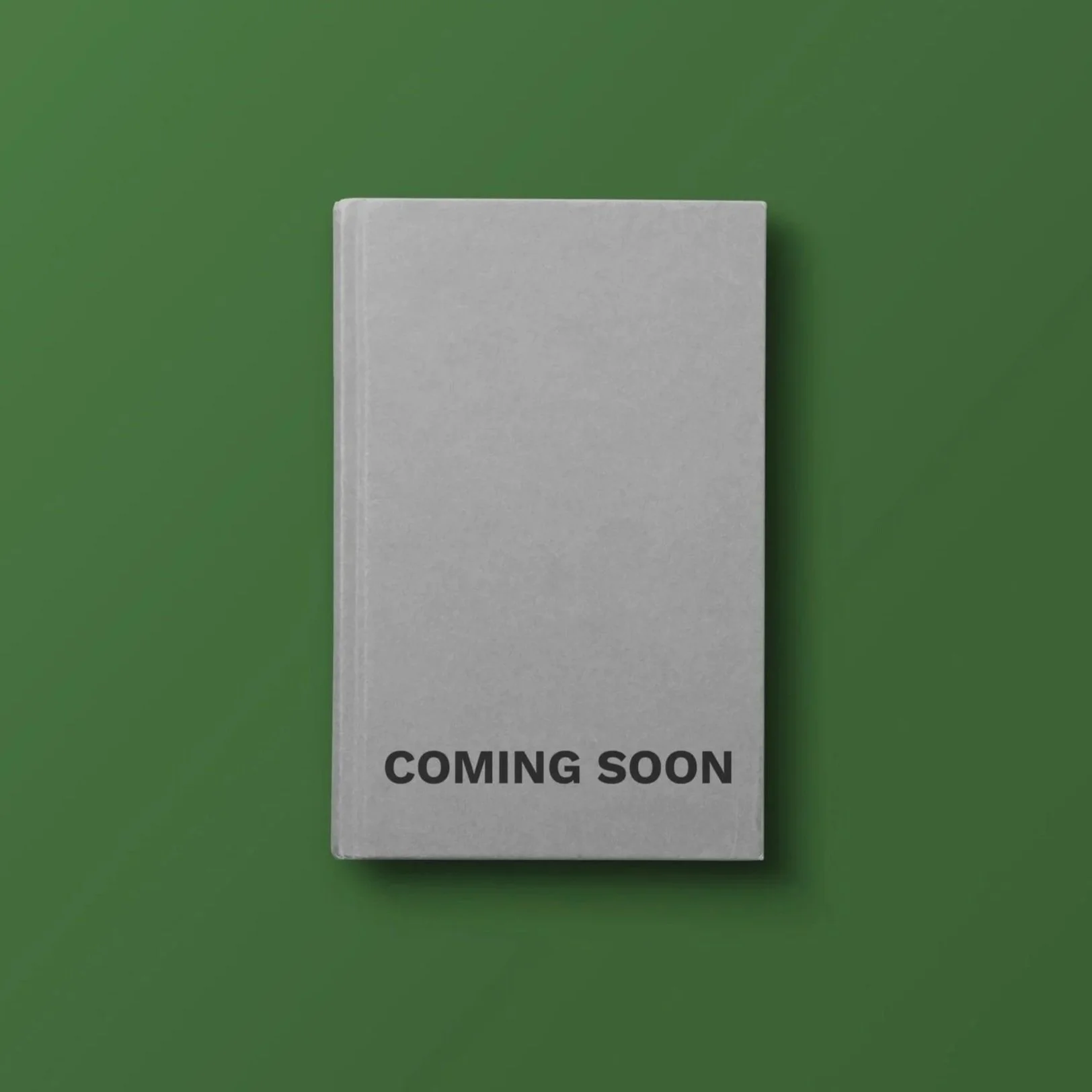 A grey rectangular book mockup with black text reading 'COMING SOON' against a green background.
