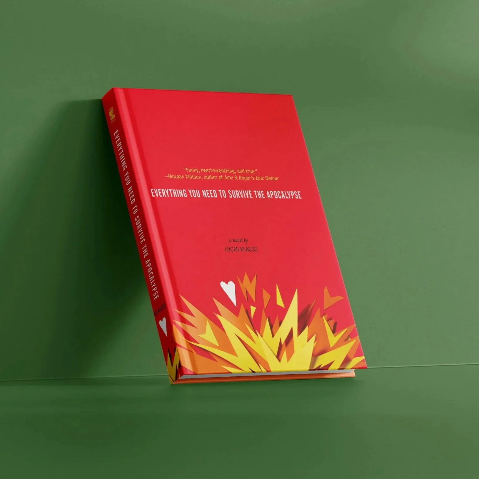 Red book titled "Everything You Need to Survive the Apocalypse" with orange, yellow, and white explosion graphic on cover, lying on a green surface.