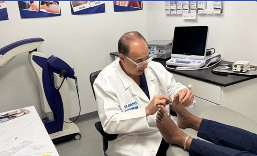 A doctor examining a patient's feet in a medical office.