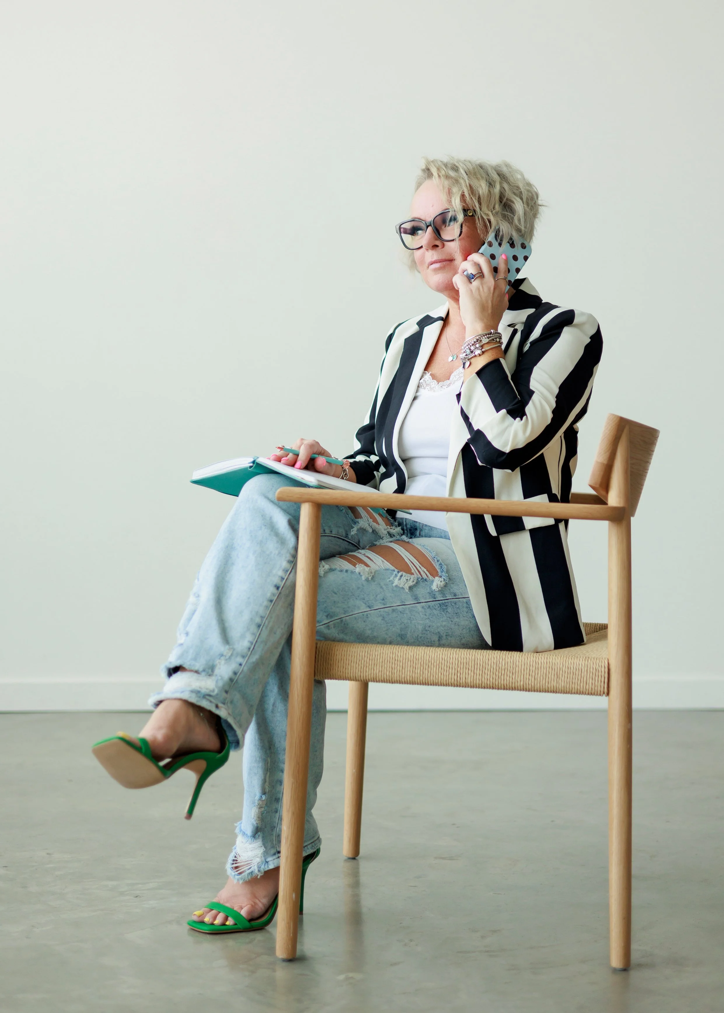 striped blazer ripped jeans polkadot phone case black glasses green Steve Madden heels woman talking on the phone gucci glasses