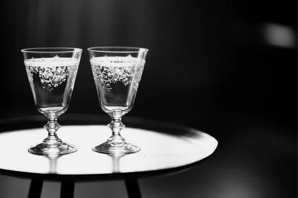 Deux verres à pied pleins d'eau pétillante avec des bulles, placés sur une table ronde