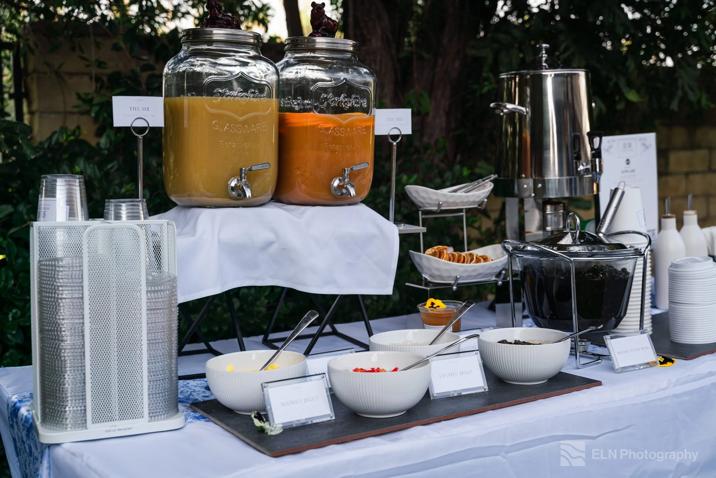 Overhead view of luxury boba catering setup with toppings, milk teas, teas, specialty drinks, and garnishes.