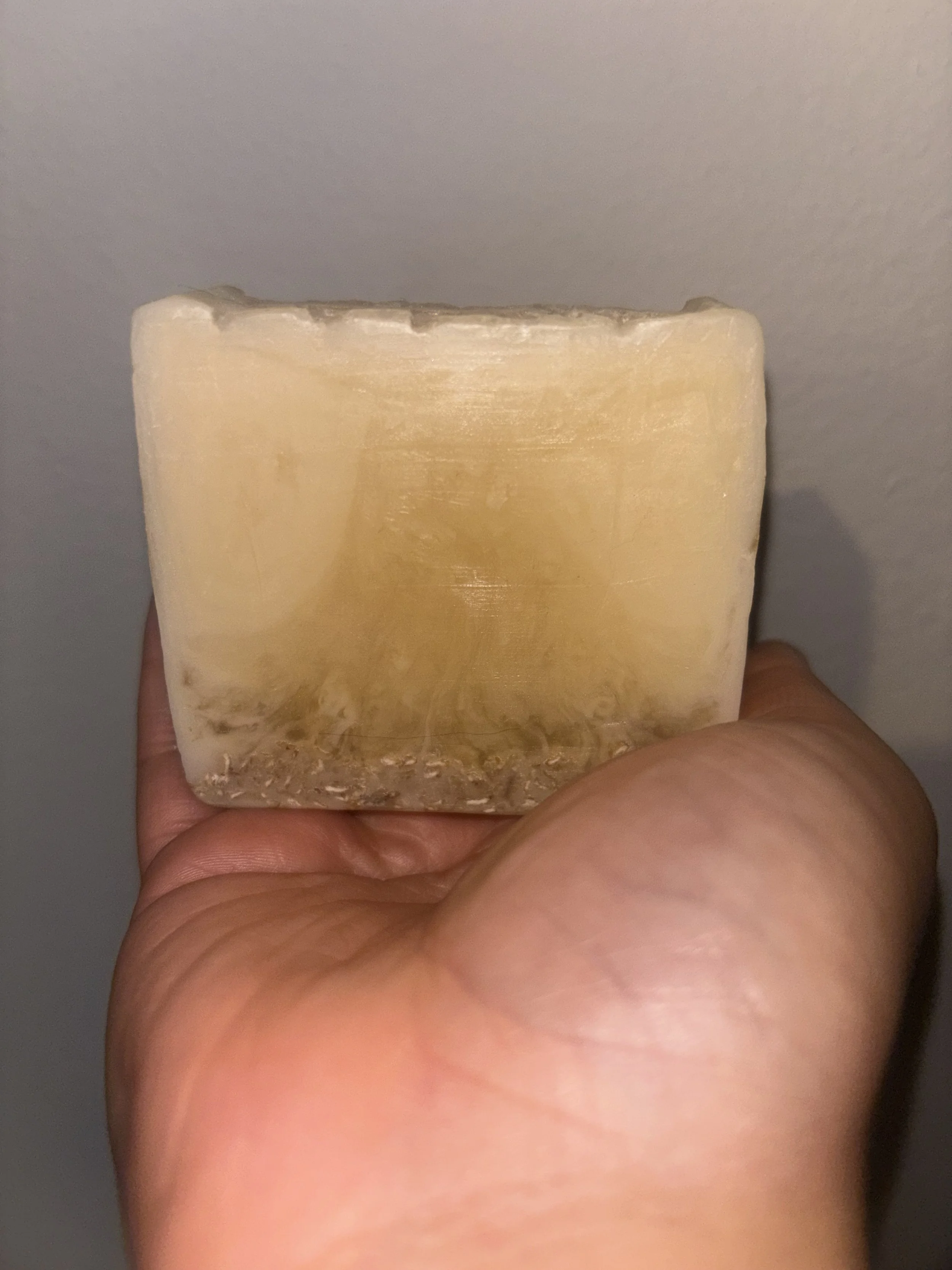 Close-up of a large bar of soap being held by a person's hand.