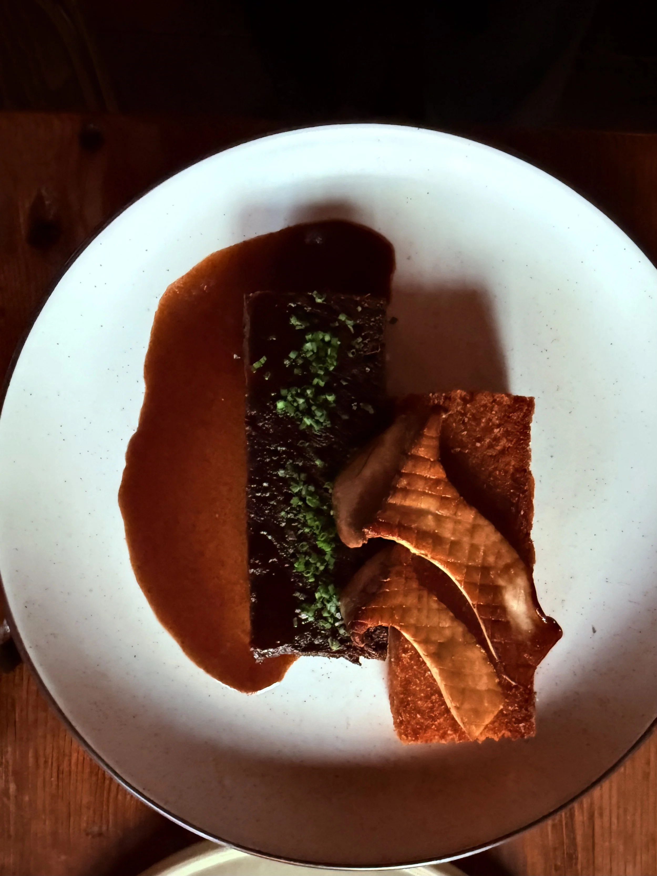 A pressed beef shank with a fried latke charred mushroom and a beef Demi glacé