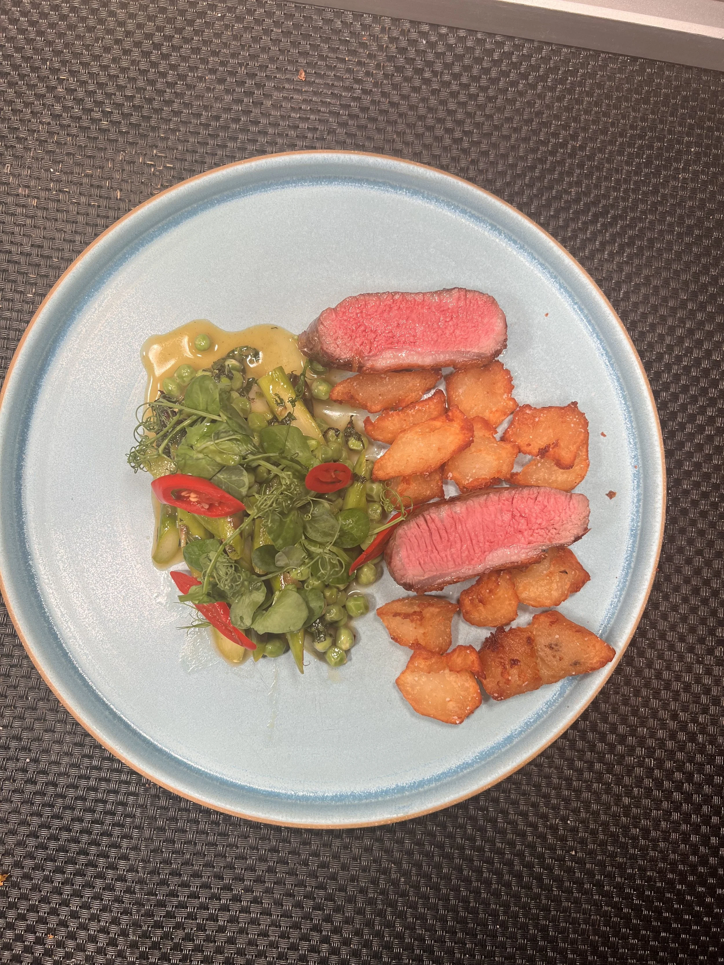 Lamb, roasted potatoes, and a side salad with mixed greens and pickled Fresno peppers