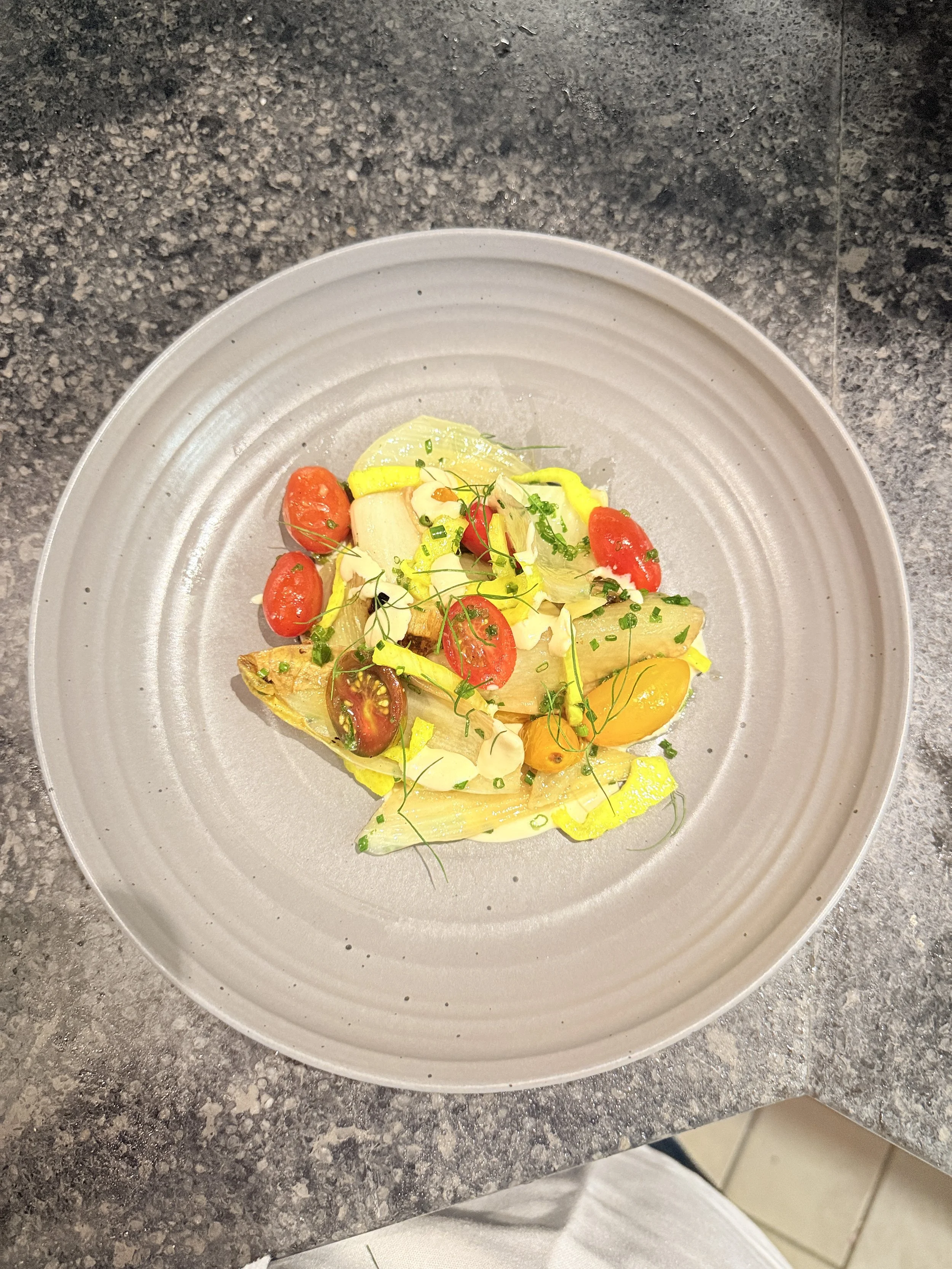 A confit fennel salad, roasted endive with cherry tomatoes and an almond taritor