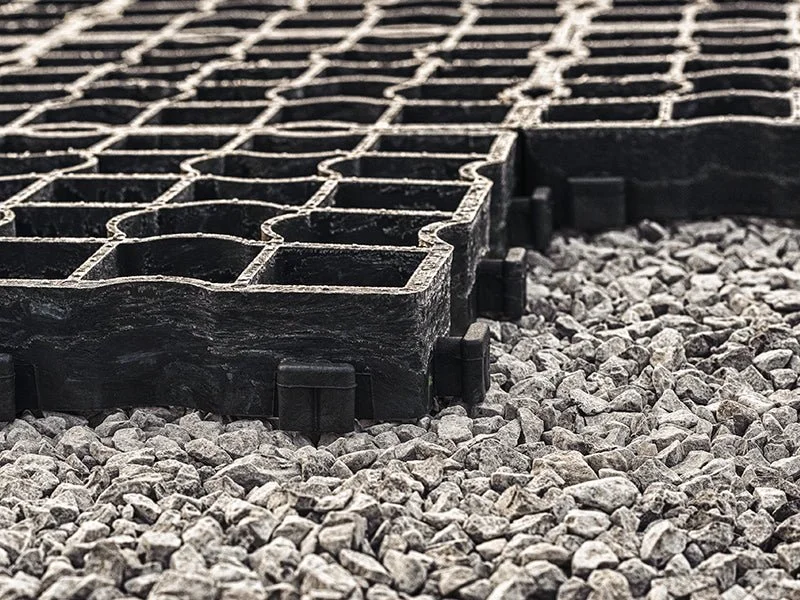 A close-up image of concrete paving cells placed on a bed of gravel.