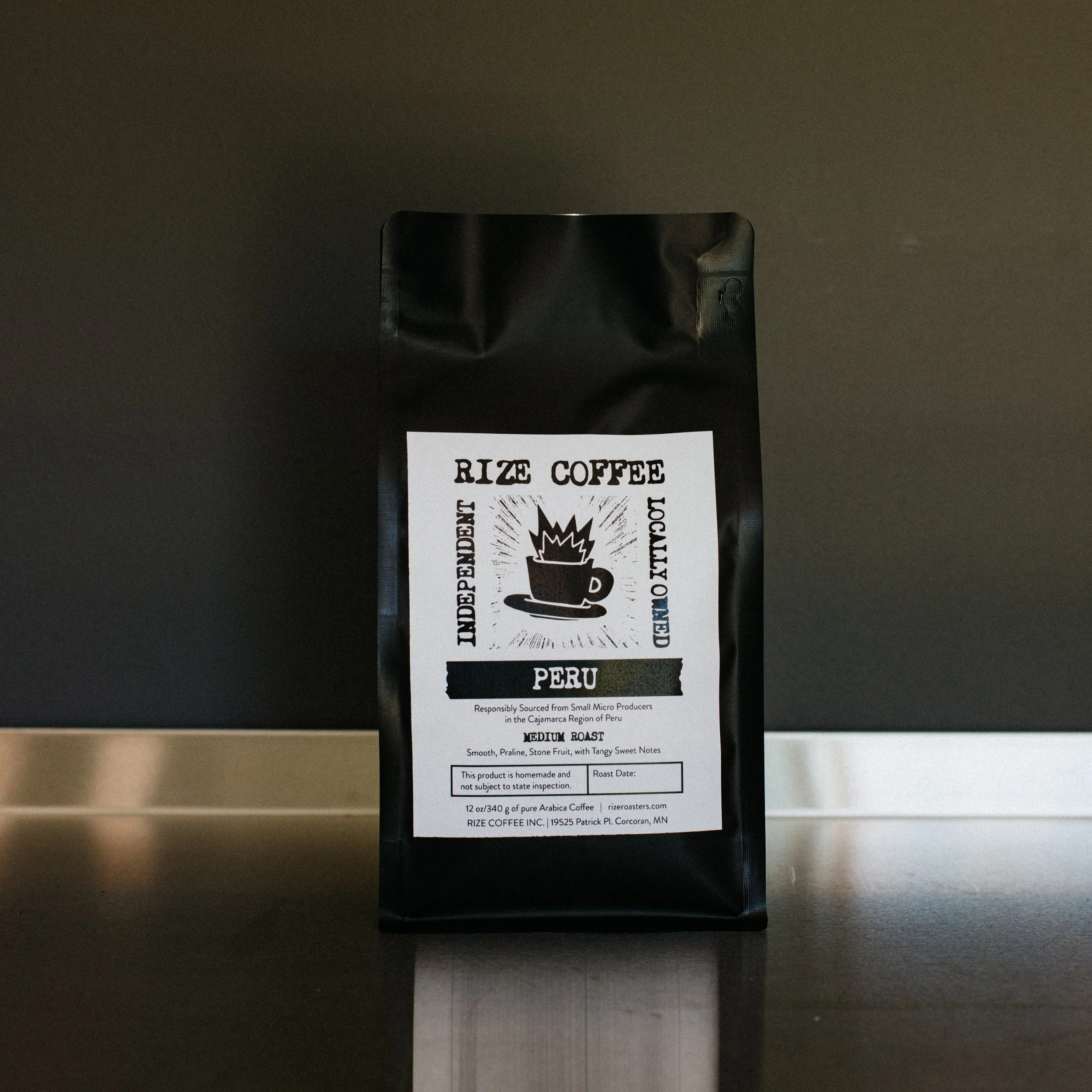 A black bag of Rize Coffee brand Arabica coffee from Peru, medium roast, with tasting notes of smooth, praline, and stone fruit, and a warning that the product is homemade and not subject to official inspection.