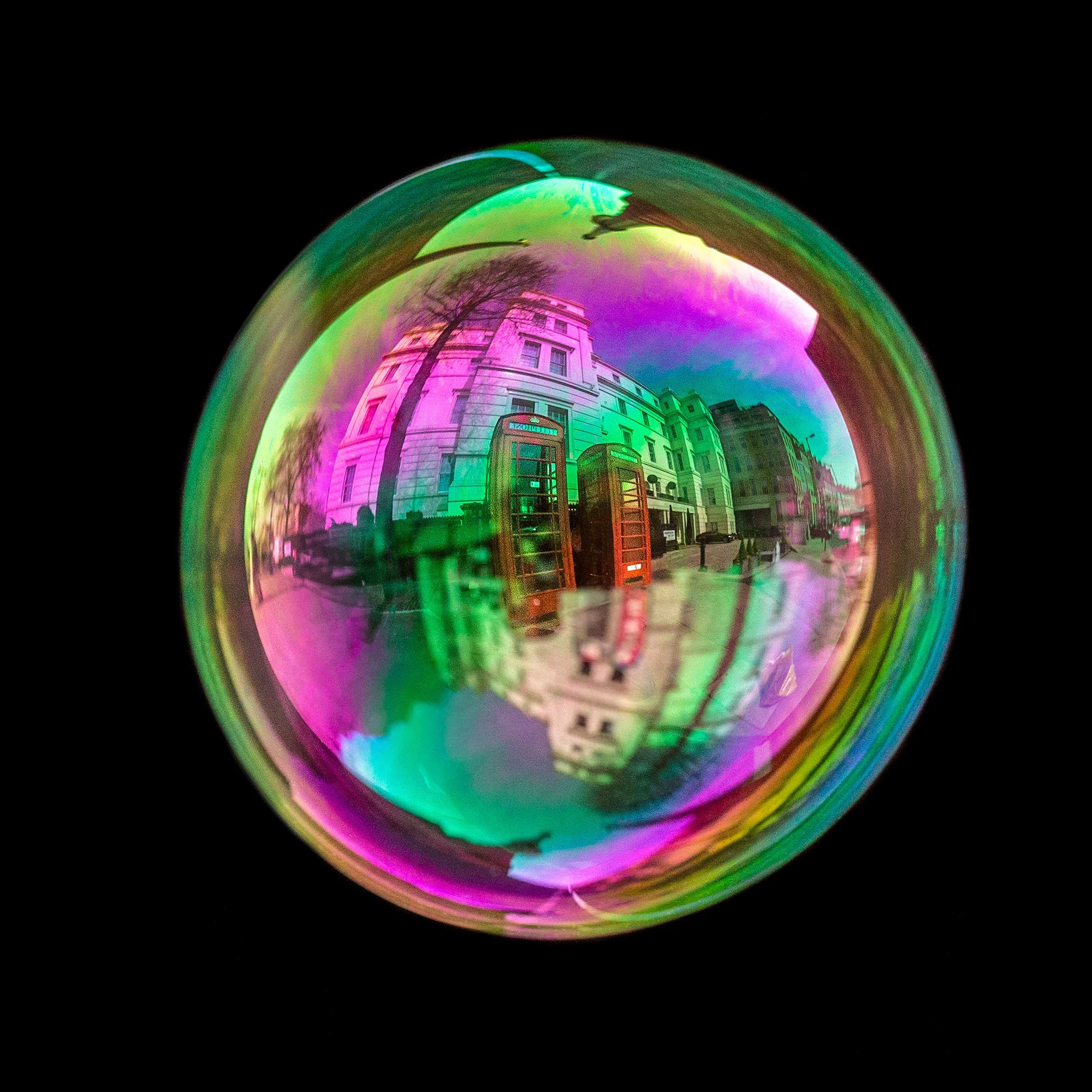Real bubble photograph featuring traditional London red telephone booths and natural light reflections