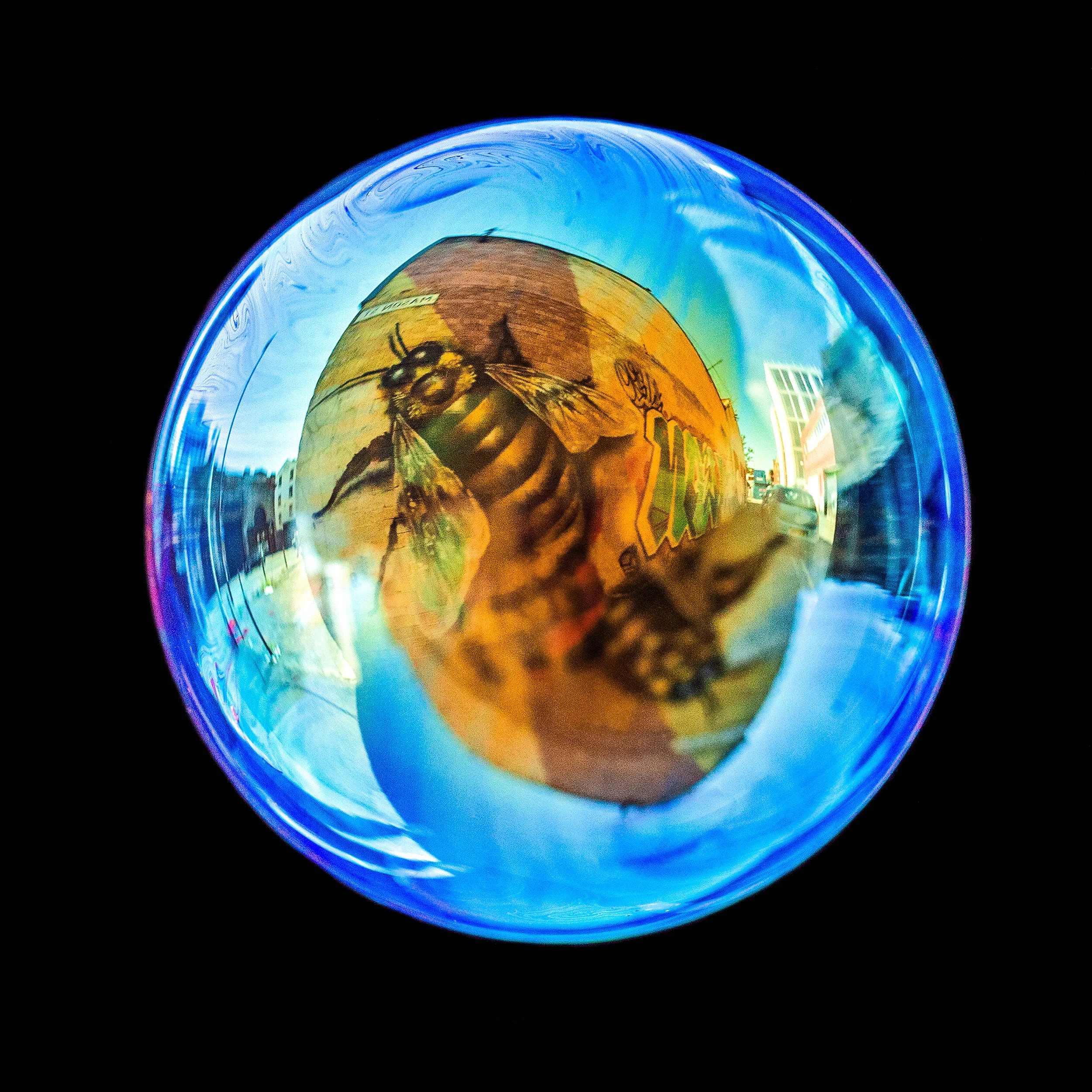 Real bubble photograph featuring Manchester bee graffiti and natural light reflections
