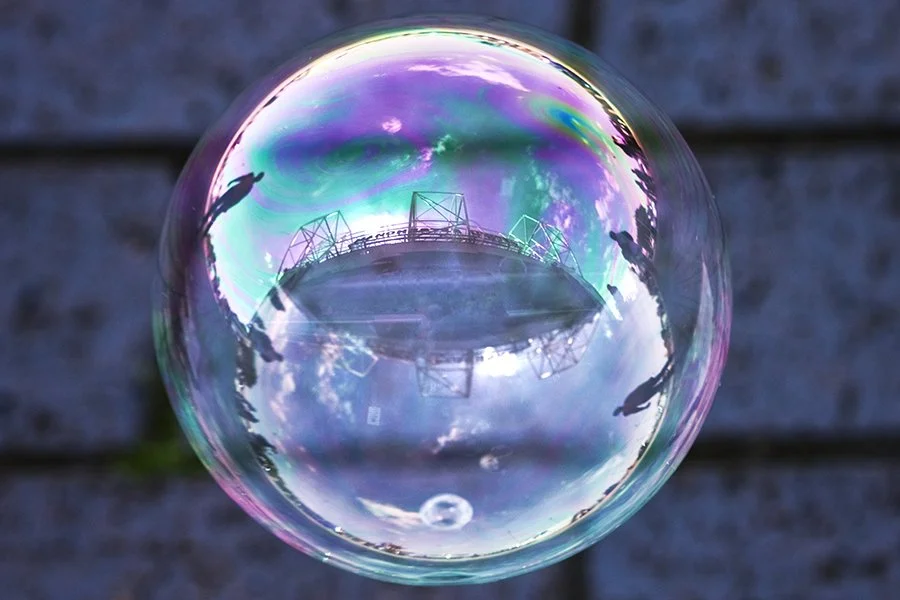 old trafford football stadium home of manchester united photographed reflected on the surface of soap bubble