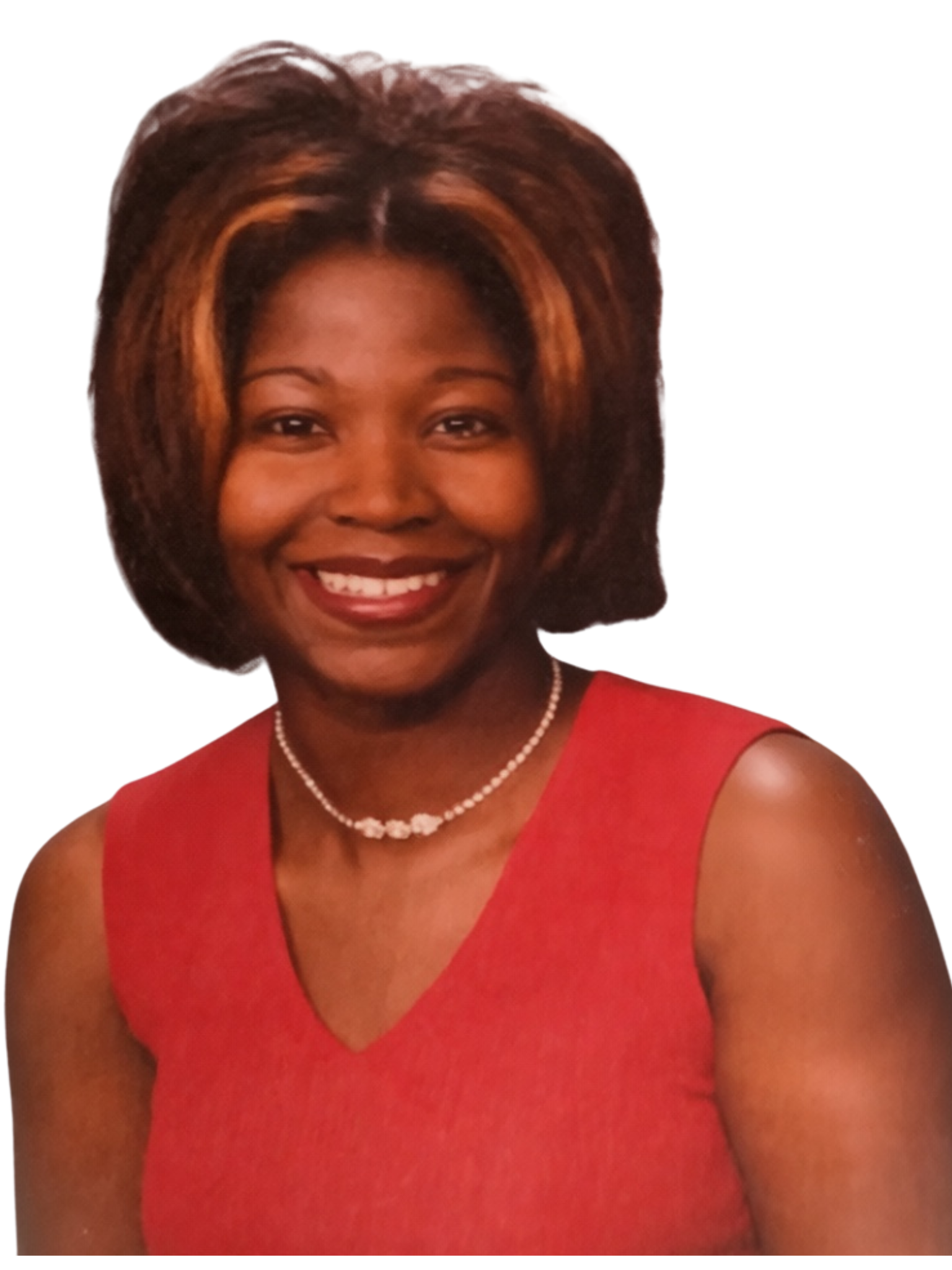 Close-up of a smiling woman with short hair, wearing a red dress, pearl necklace, and makeup. The background is dark.