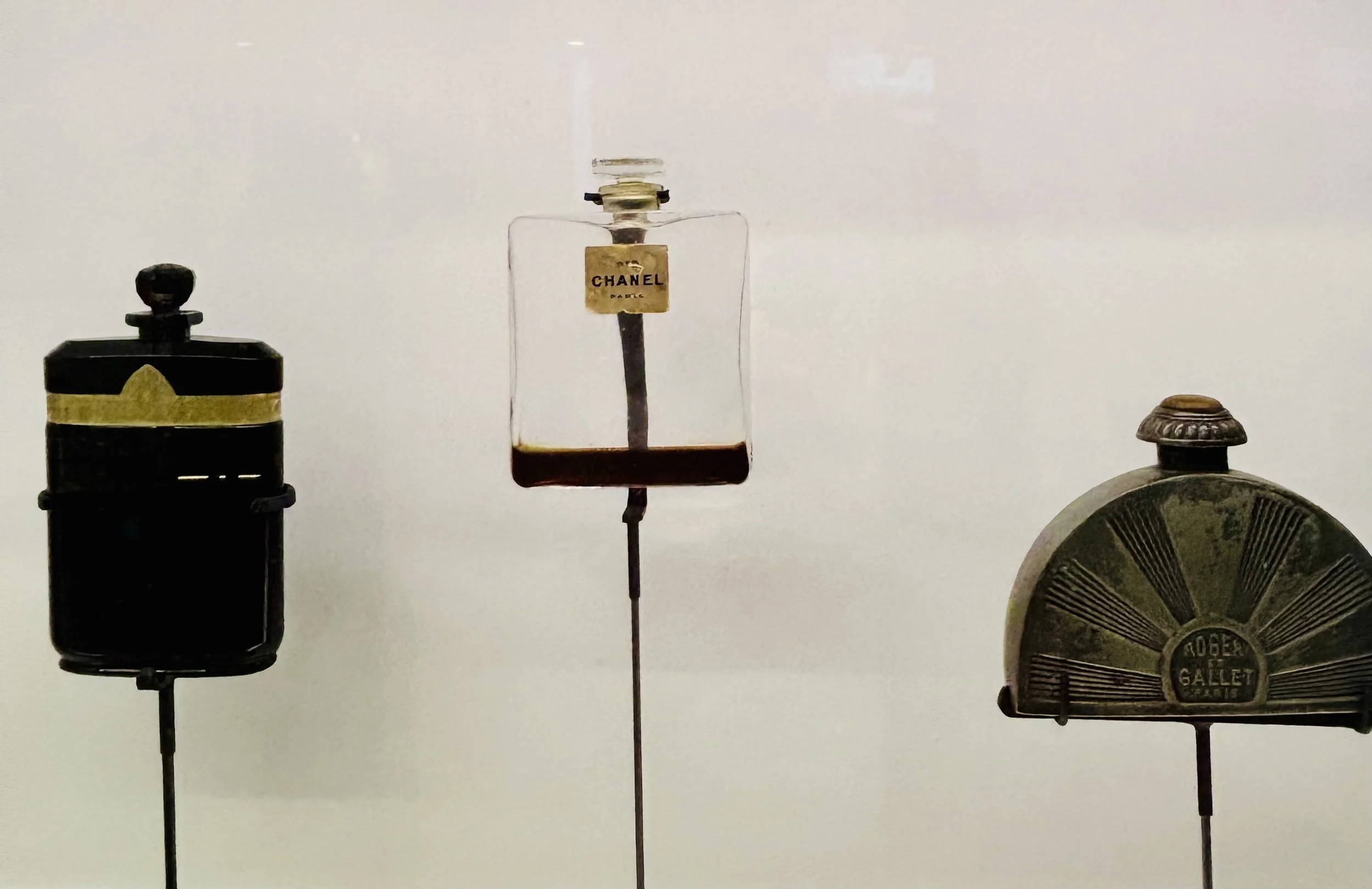 Three vintage metal mailbox front panels mounted on black stands against a plain white background, with the middle one labeled 'Chanel Paris'.