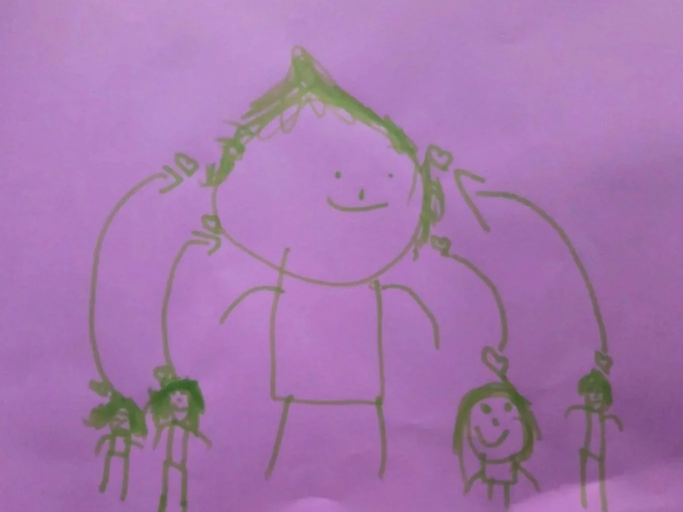 A simple childlike drawing on purple paper of a person with green hair, smiling, with four smaller figures hanging from hands with hearts, indicating a happy family or group.