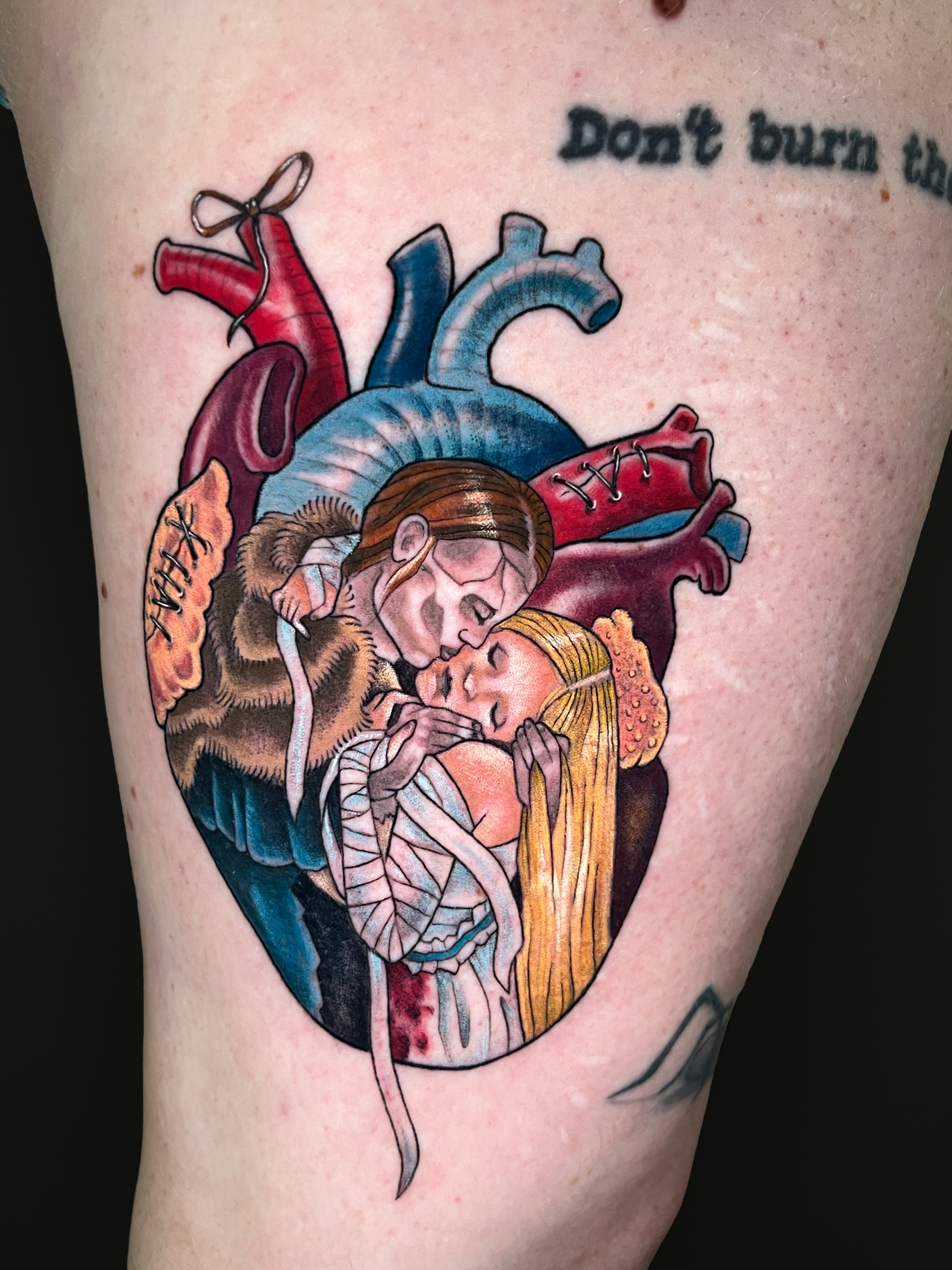 Tattoo of a detailed anatomical heart with realistic shading and vibrant colors, located on a person's arm.