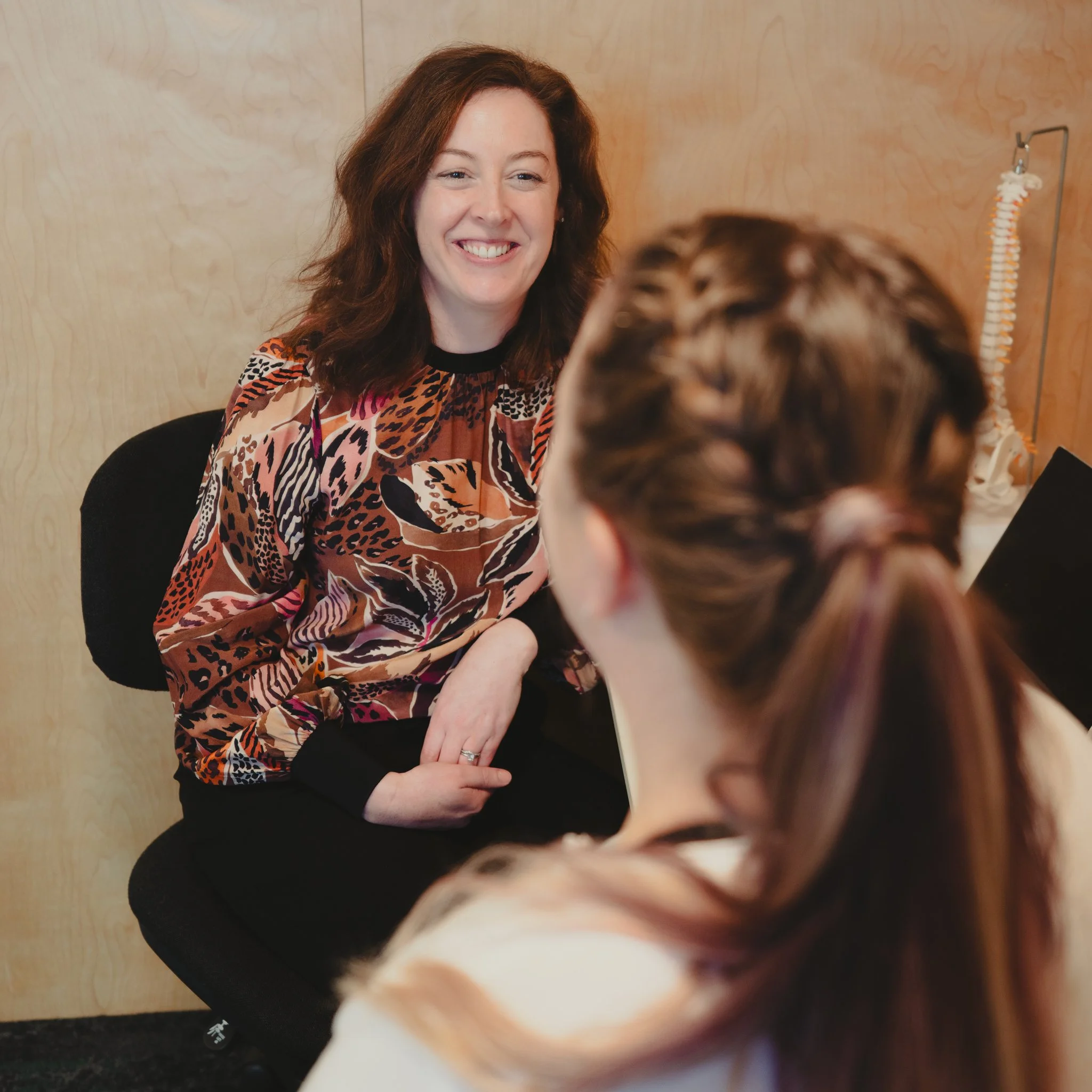 Marianne Carroll from Align and Uplift smiling warmly with a client during a women's health consultation in Southland New Zealand