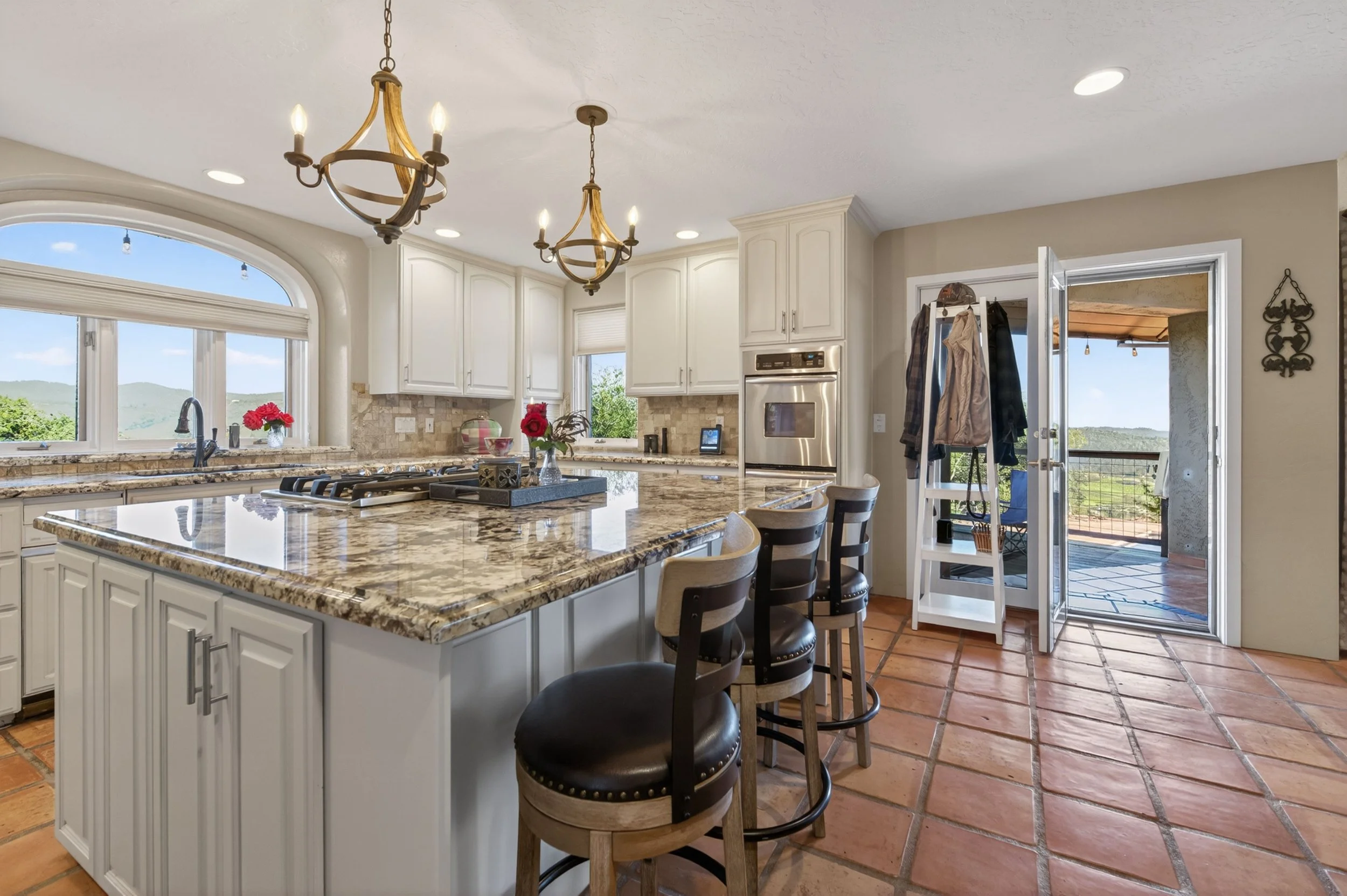 Spacious gourmet kitchen in Vallecito California featuring custom cabinetry, stone countertops, and natural light-filled design