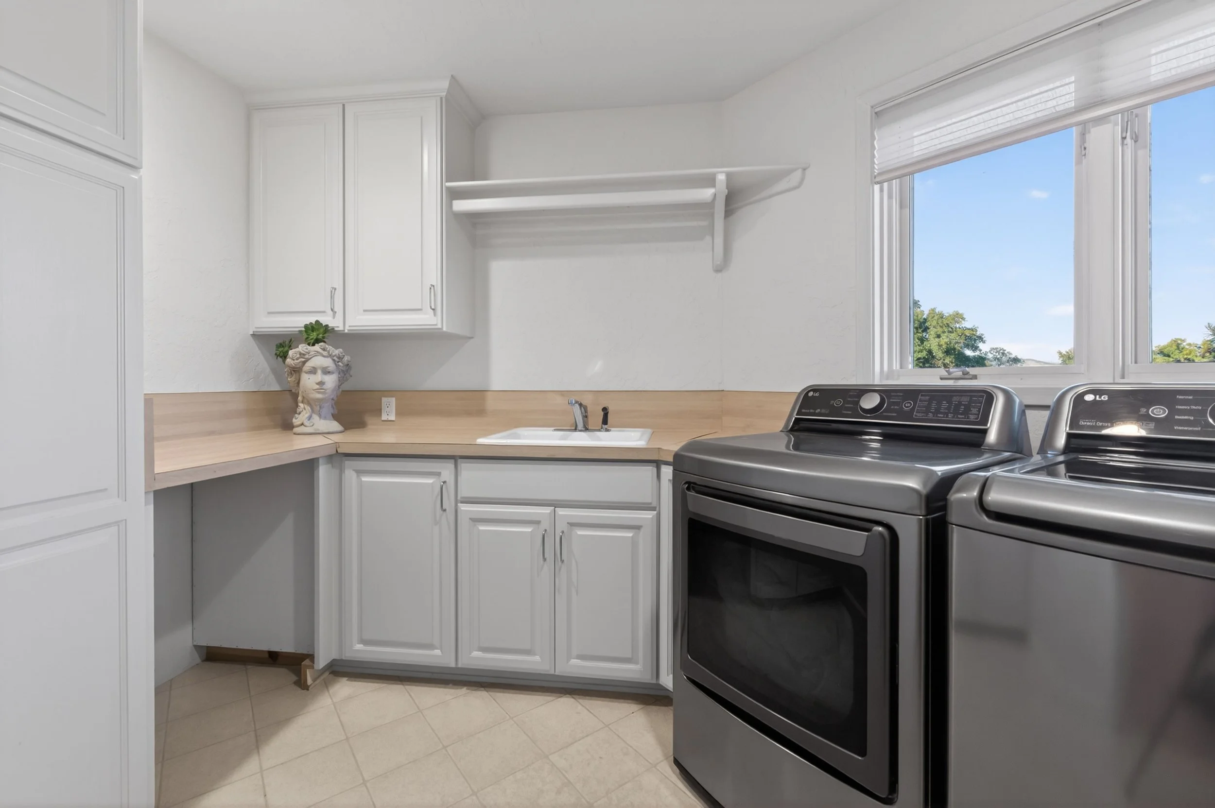 Laundry and utility room at Airola Ranch in Vallecito California featuring custom cabinetry, natural light, and functional luxury estate design