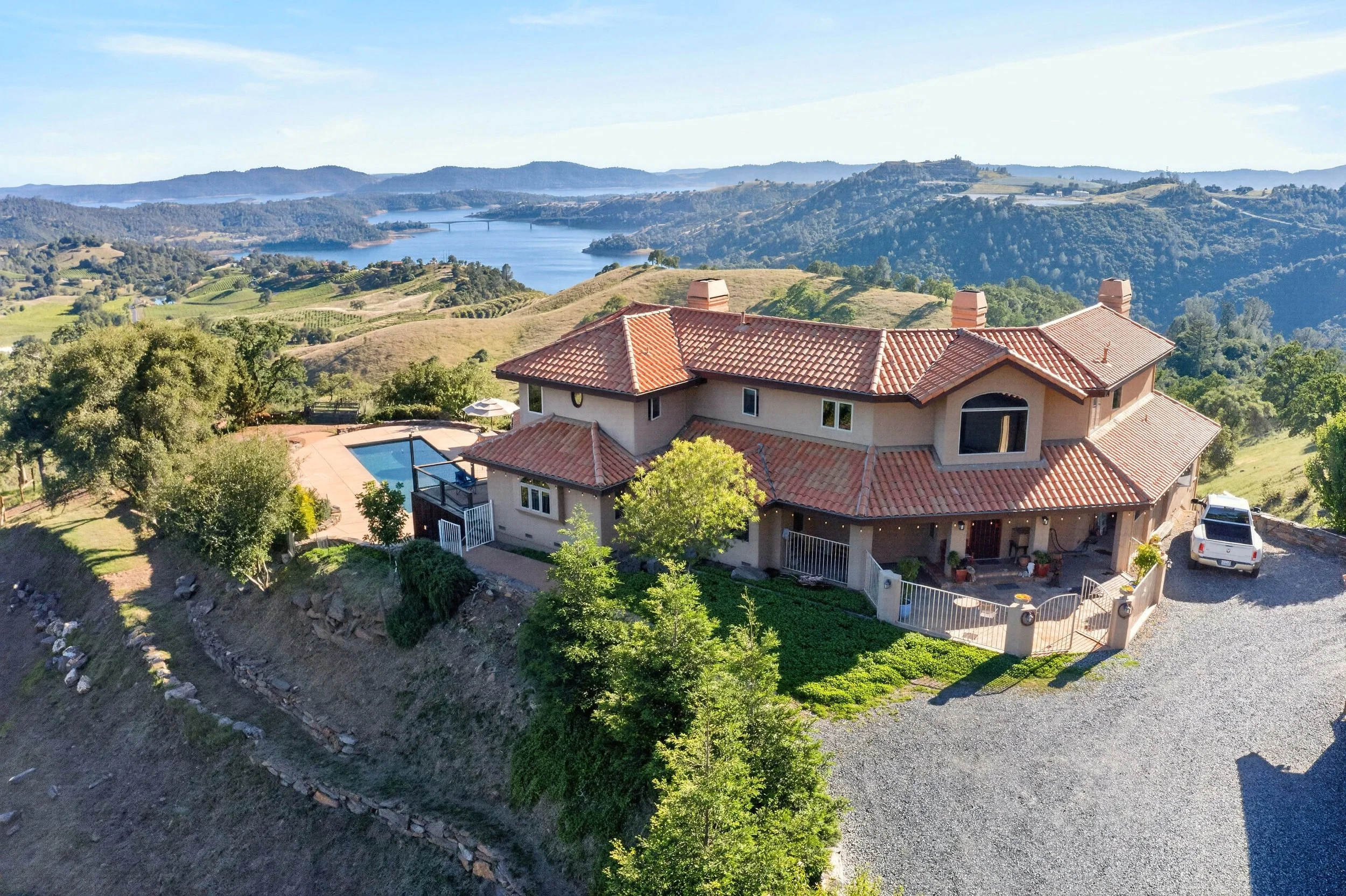 Luxury estate at 7570 Airola Rd in Vallecito California overlooking New Melones Lake, rolling foothills, and distant Sierra Nevada mountains.