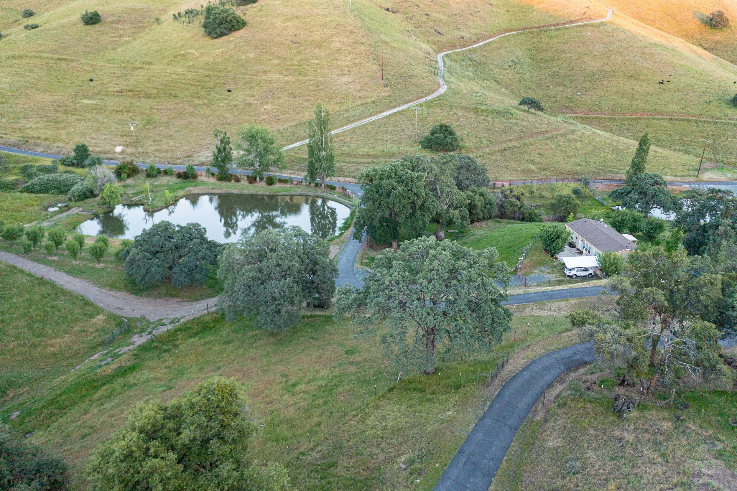 Aerial view of the guest house and private pond at Airola Ranch in Vallecito California surrounded by rolling Sierra Foothill landscapes