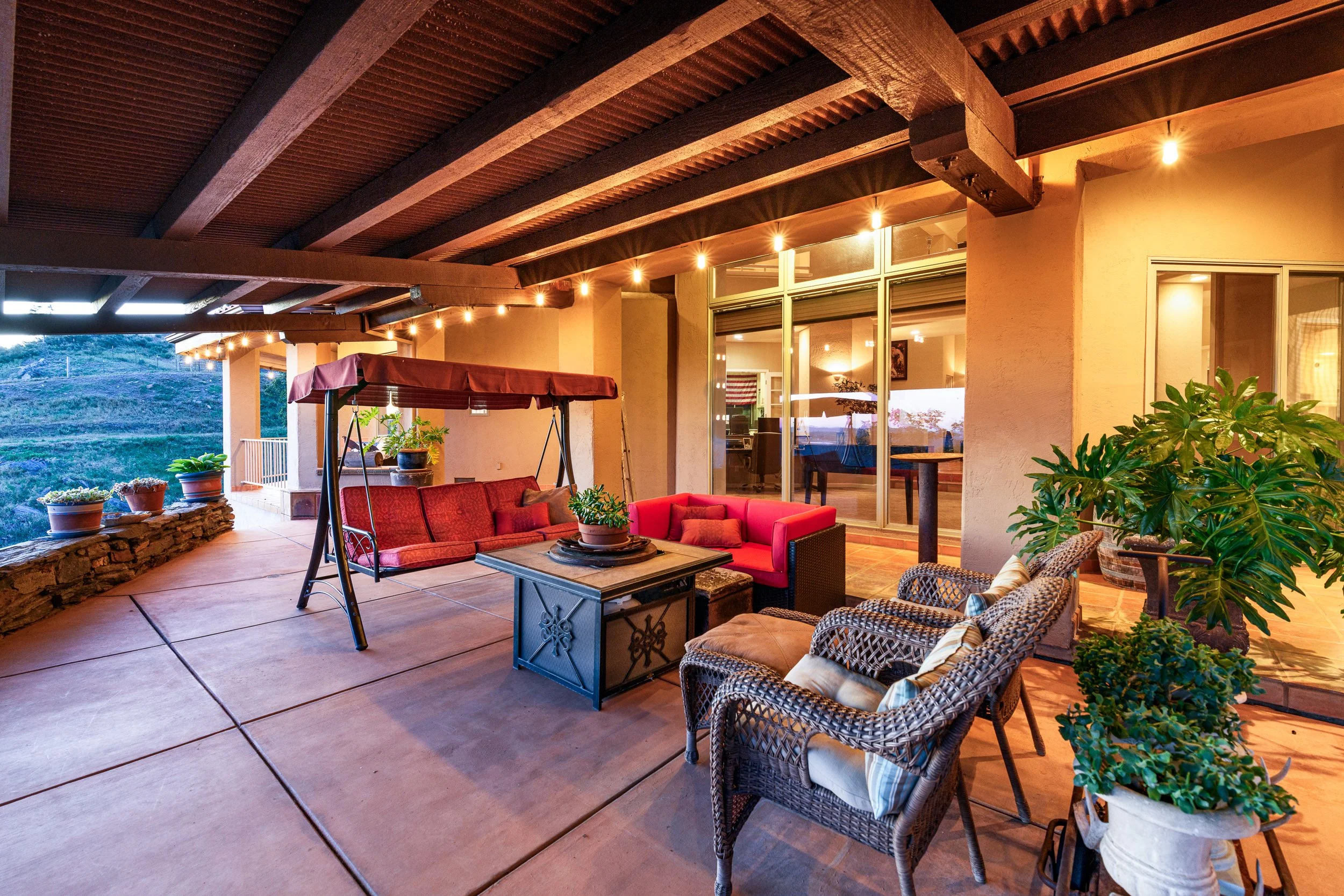 Covered outdoor living patio at Airola Ranch in Vallecito California featuring luxury seating, exposed wood beams, and Sierra Foothill views