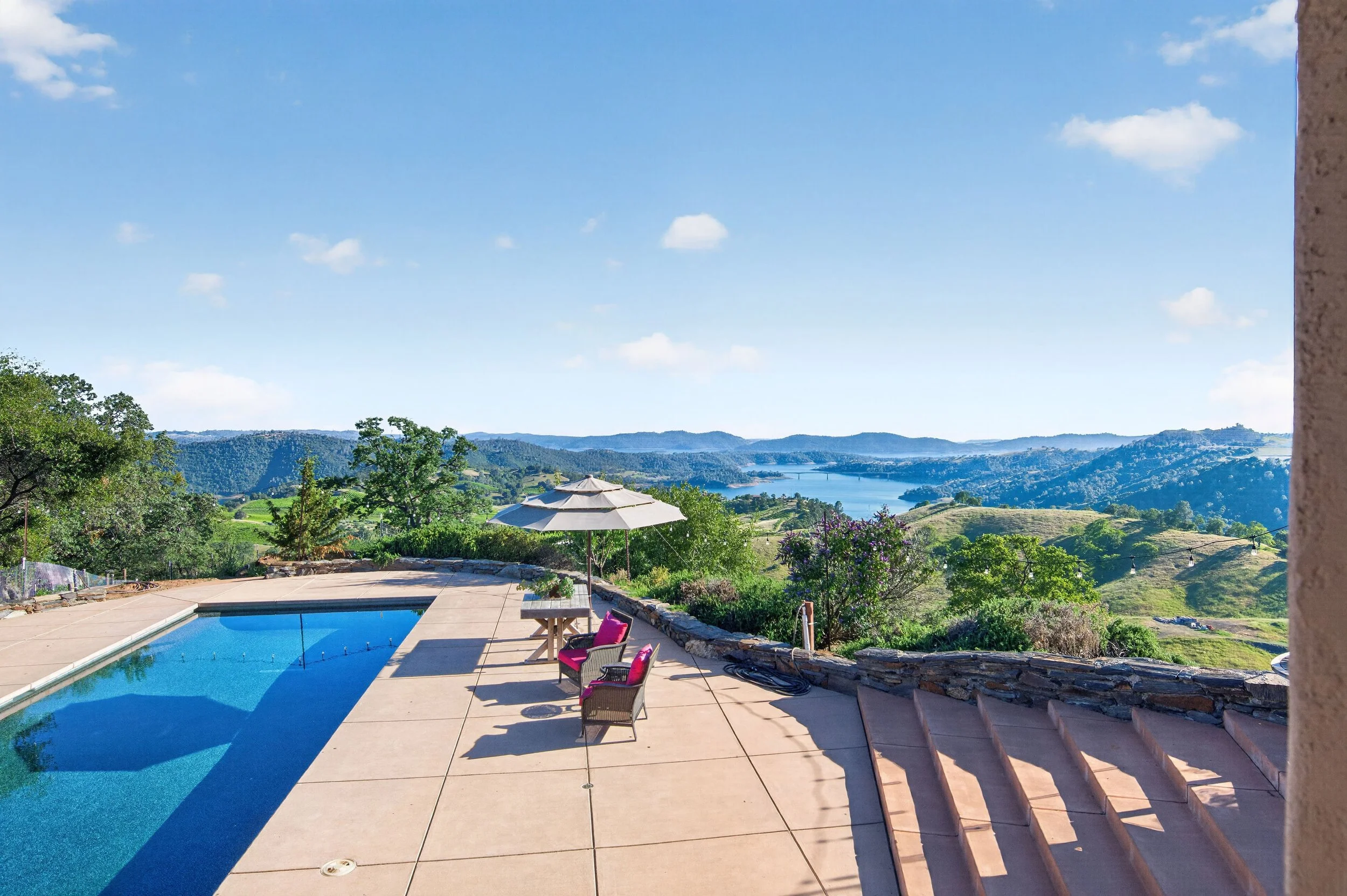Resort-style pool and outdoor entertaining area at Airola Ranch in Vallecito California featuring panoramic foothill and New Melones Lake views.