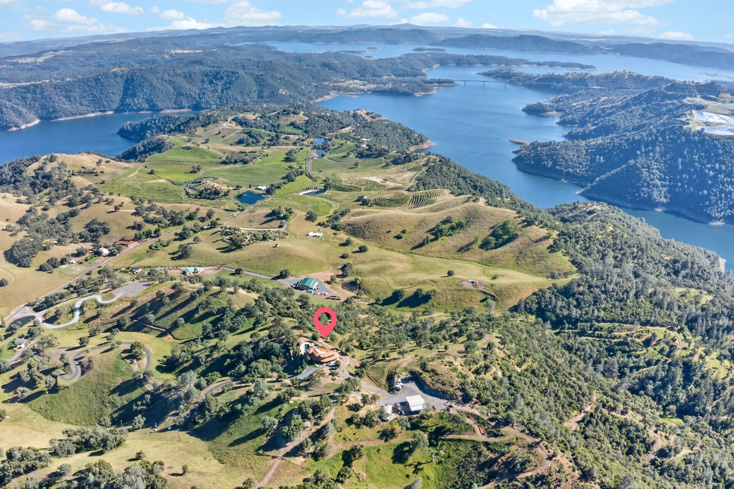 Aerial view of Airola Ranch in Vallecito California featuring rolling green hills, private roads, lake views, and scenic Sierra Foothill landscapes